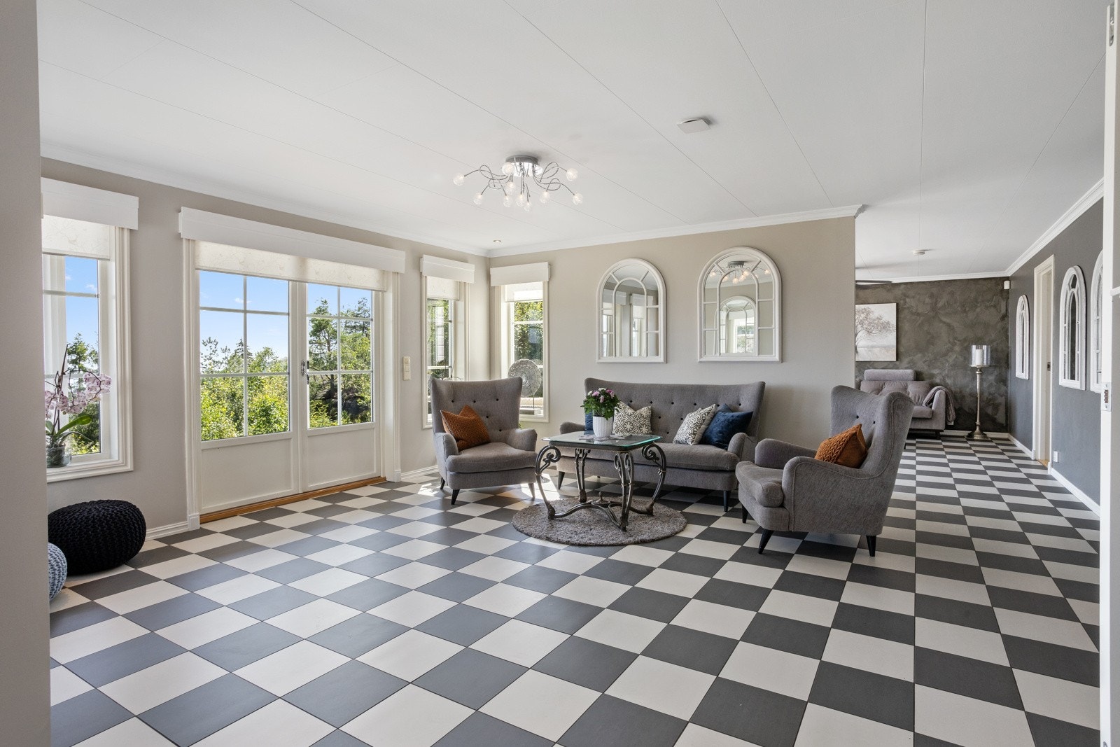 Hovedstuen med dobbeldør ut mot hellelagte og steinsatte usjenerte utearealer Galleribilde