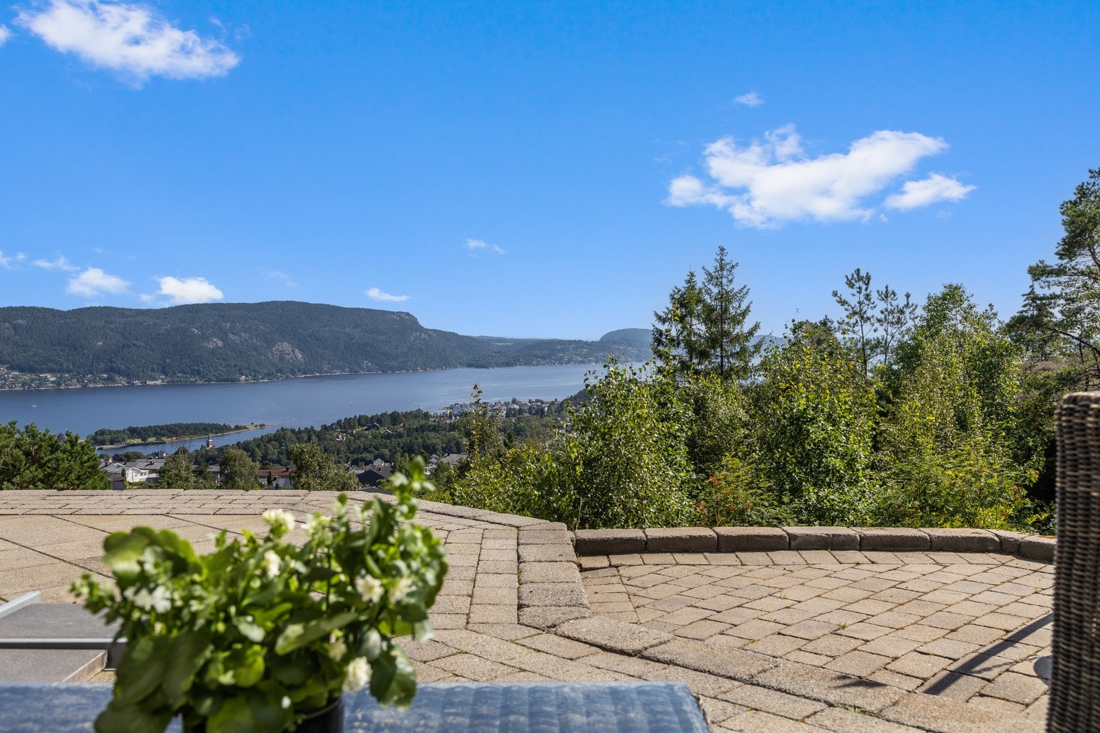 Store steinsatte og hellelagte utearealer både foran og bak huset Galleribilde