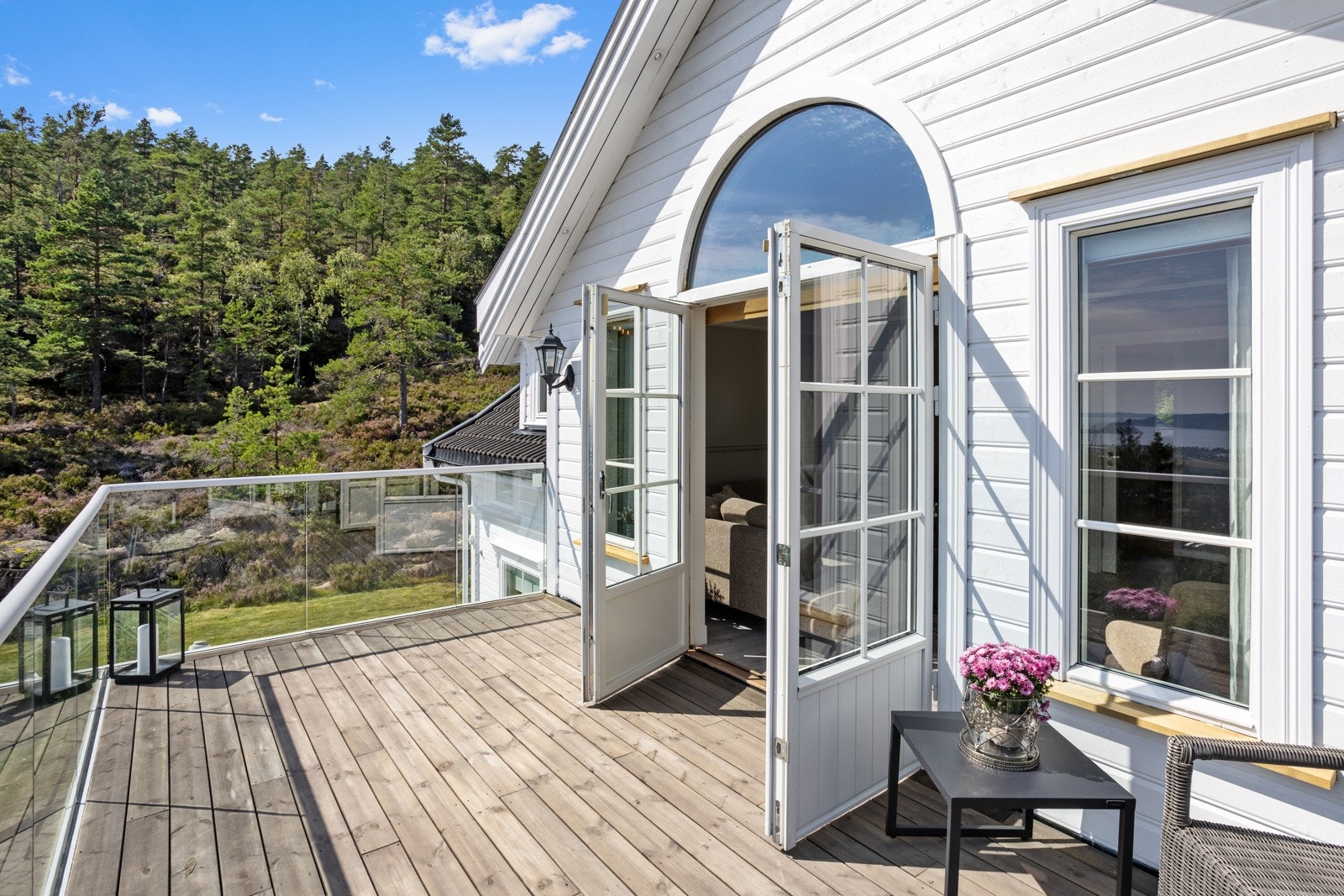 Elegant med dobbeldør ut til den romslige balkongen utenfor tv-stuen i 2. etasje Galleribilde