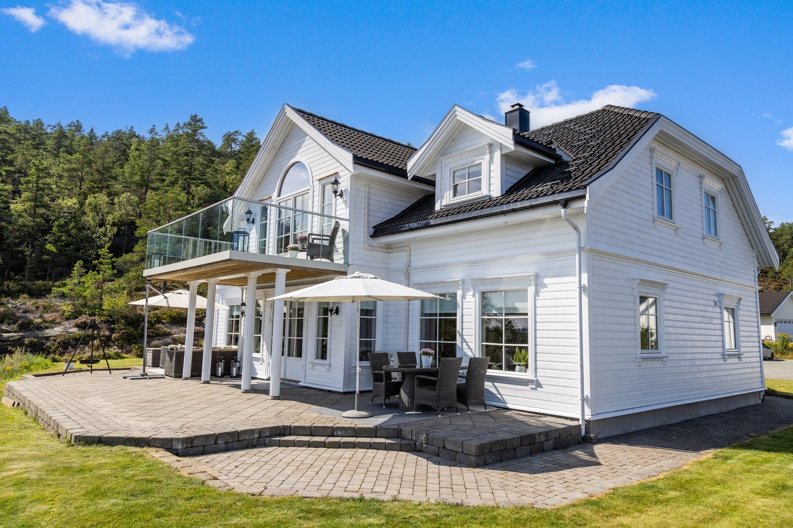 Store steinsatte utearealer foran, bak - og på sidene av huset Galleribilde