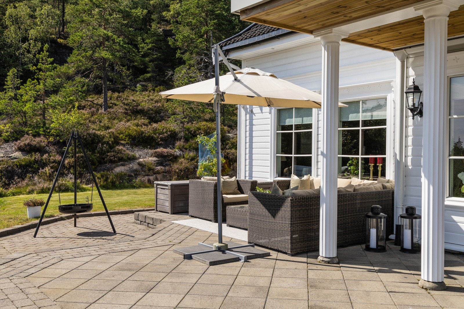 Store steinsatte og hellelagte utearealer både foran og bak huset Galleribilde