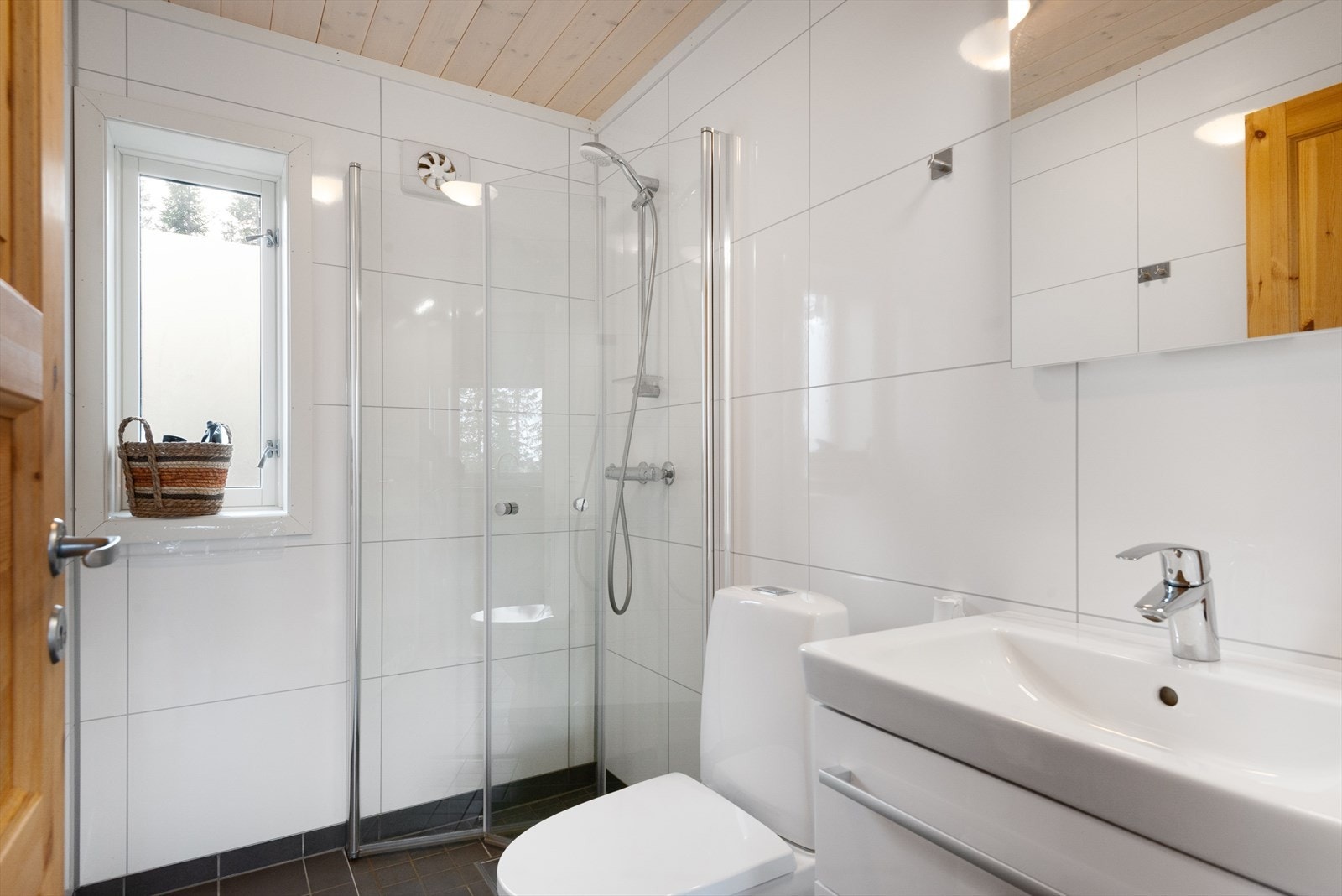 Hytta har et pent bad i tidløse farger og materialvalg. Flislagt gulv med varmekabler. Galleribilde