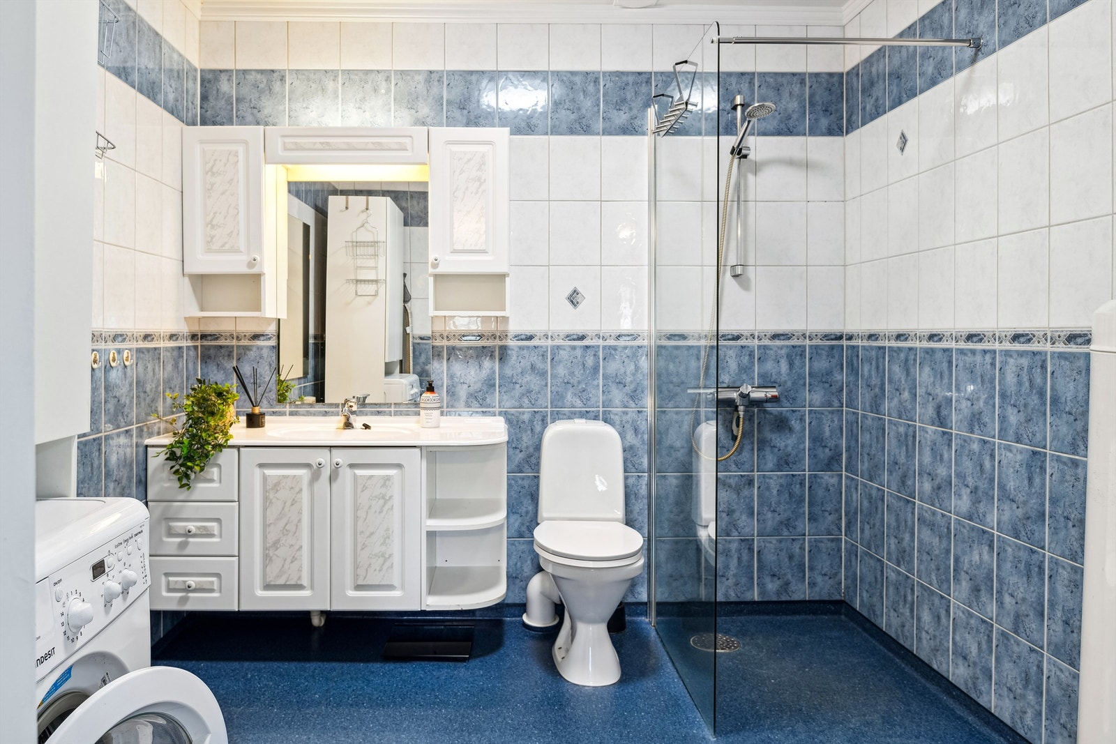 Stort bad med dusjhjørne, innredning, wc og opplegg for vaskemaskin. Galleribilde