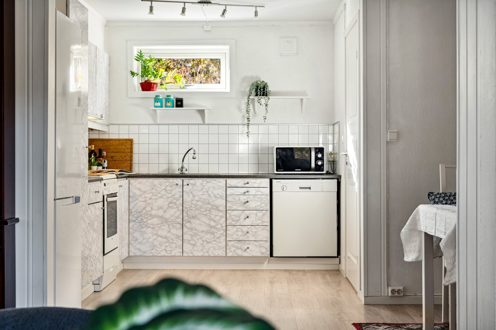 Kjøkken med åpen løsning for hvitevarer og en praktisk bod/spisskammers Galleribilde