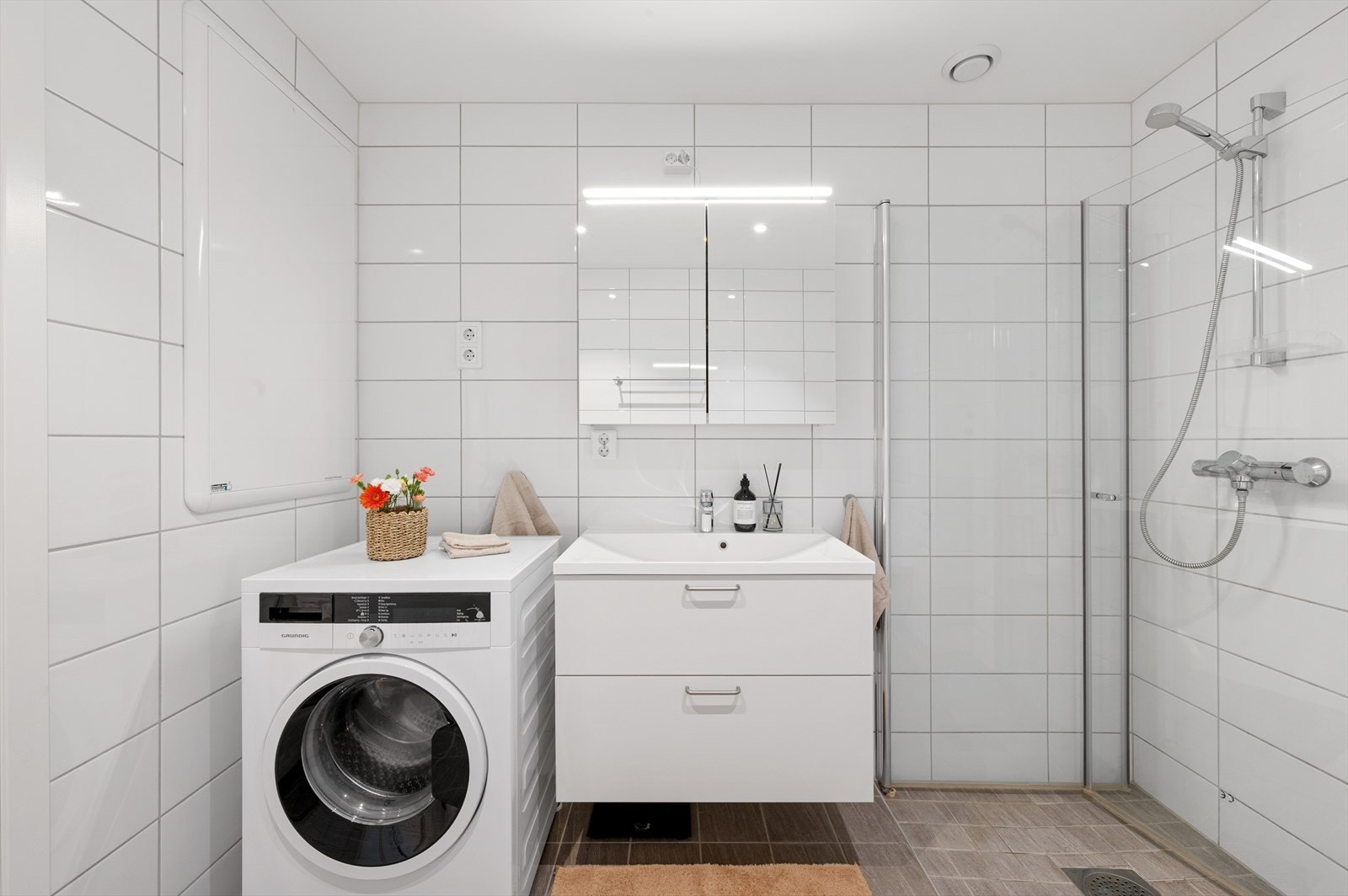 - Badet inneholder benkeskap med servant, dusjdører, vegghengt toalett og opplegg for vaskemaskin. Merk at du også har plass til tørketrommel - Galleribilde