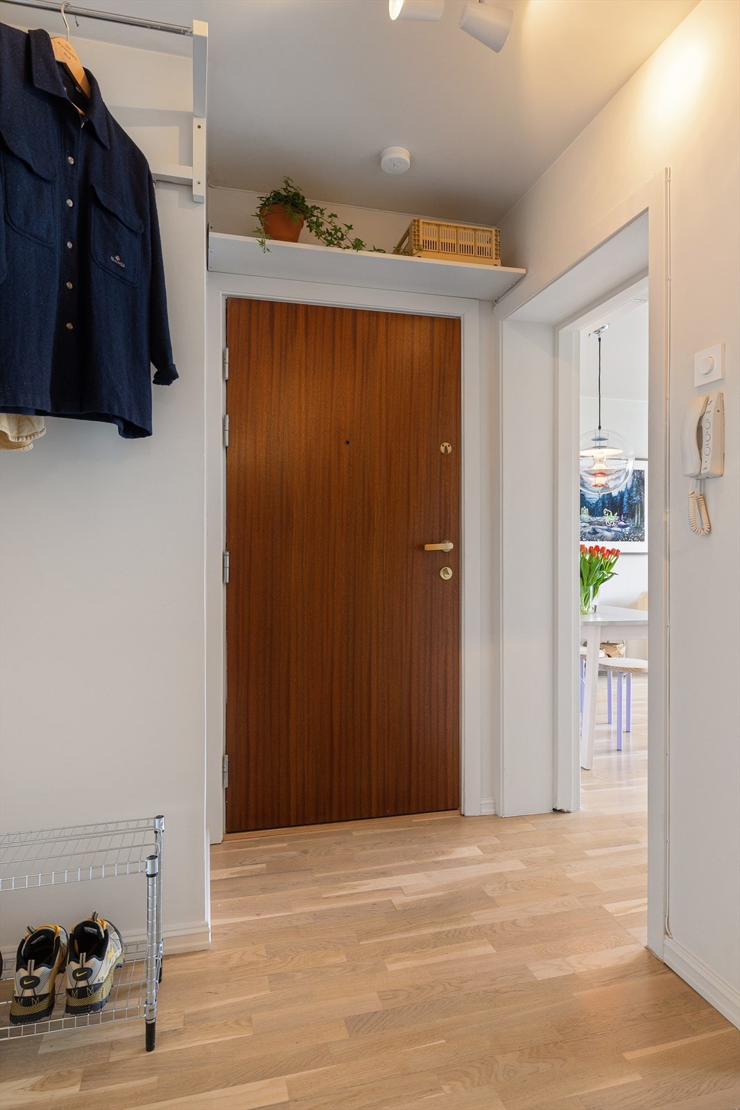 Entréen fungerer som et bindeledd mellom stuen og kjøkkenet, her er går de smarte oppbevaringsløsningene vi så i stuen igjen og utnytter takhøyden til det maksimale! Galleribilde