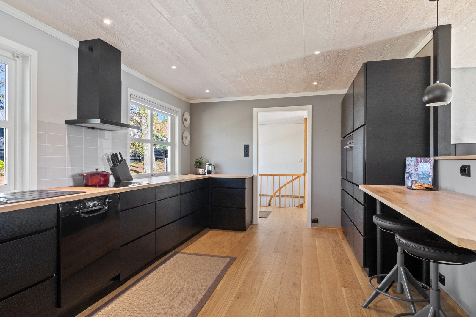 Kjøkkenet er stilrent og moderne, med sorte, glatte fronter, dobbel oppvaskkum og integrerte stikkontakter i benken. Galleribilde