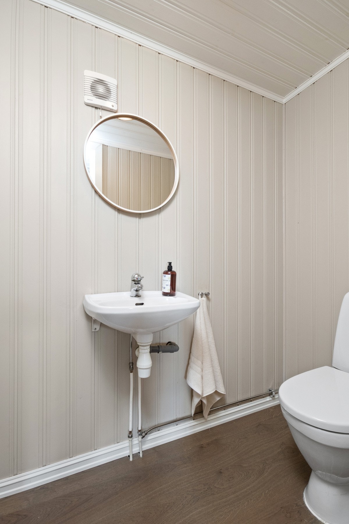 Wc-rommet nede ble pusset opp i 2016, og utenom toalettet er det 1-stavs laminatgulv og en enkel servant med tilhørende speil. Galleribilde