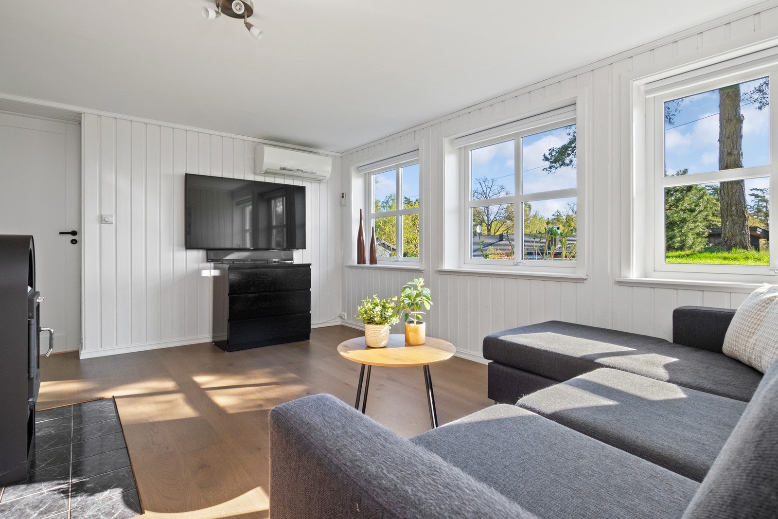 Stuen er smakfullt innredet med 1-stavs eikeparkett og hvitmalte panelvegger for et nøytralt uttrykk. Galleribilde