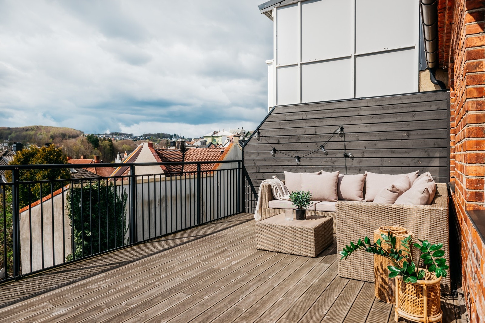 Uteplassen har rekkverk i sort smijern, utebelysning, dekke av terrassebord og en høy levegg på siden. Den flotte størrelsen gir god plass til komfortable utemøbler. Galleribilde