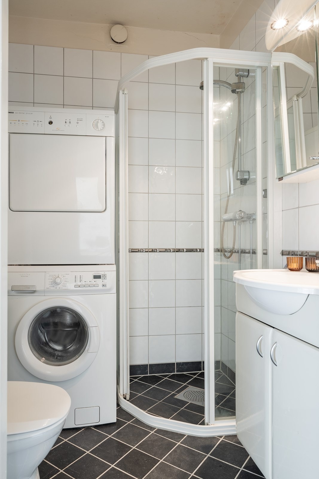 Pent flislagt baderom med god plass til dusjsone, toalett, servant og vaskemaskin. Galleribilde