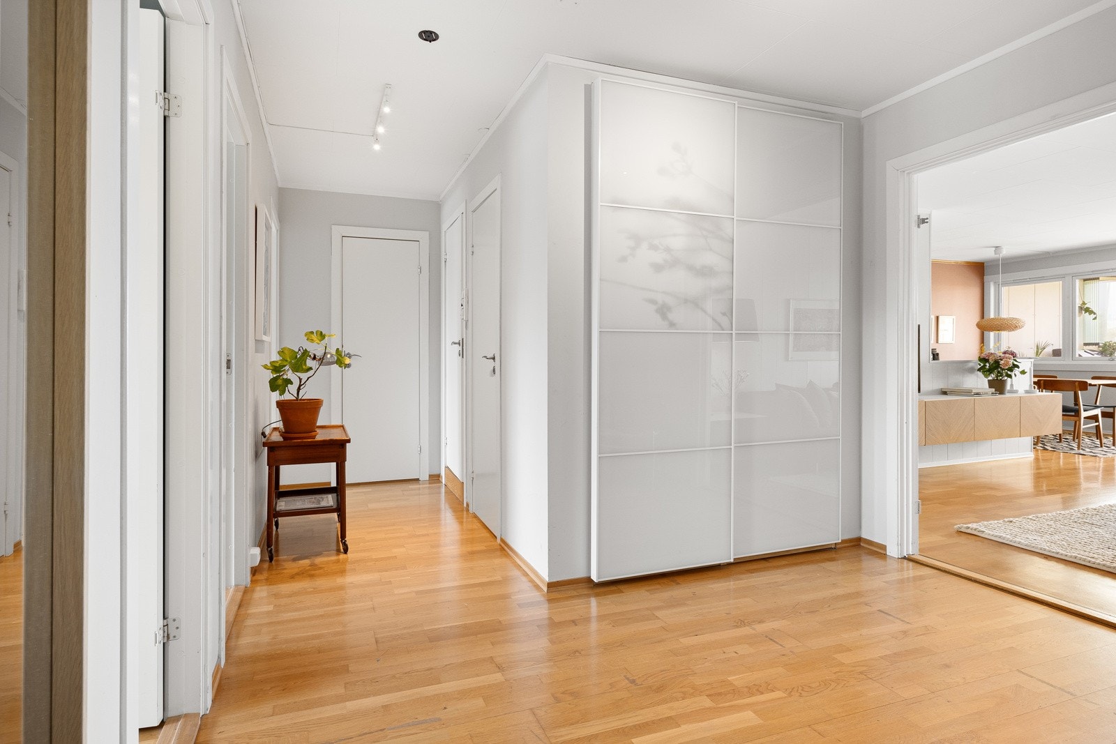 Skyvedørsgarderoben er innebygd med hvite glassfronter og i bakkant er det adkomst til en bod. Galleribilde