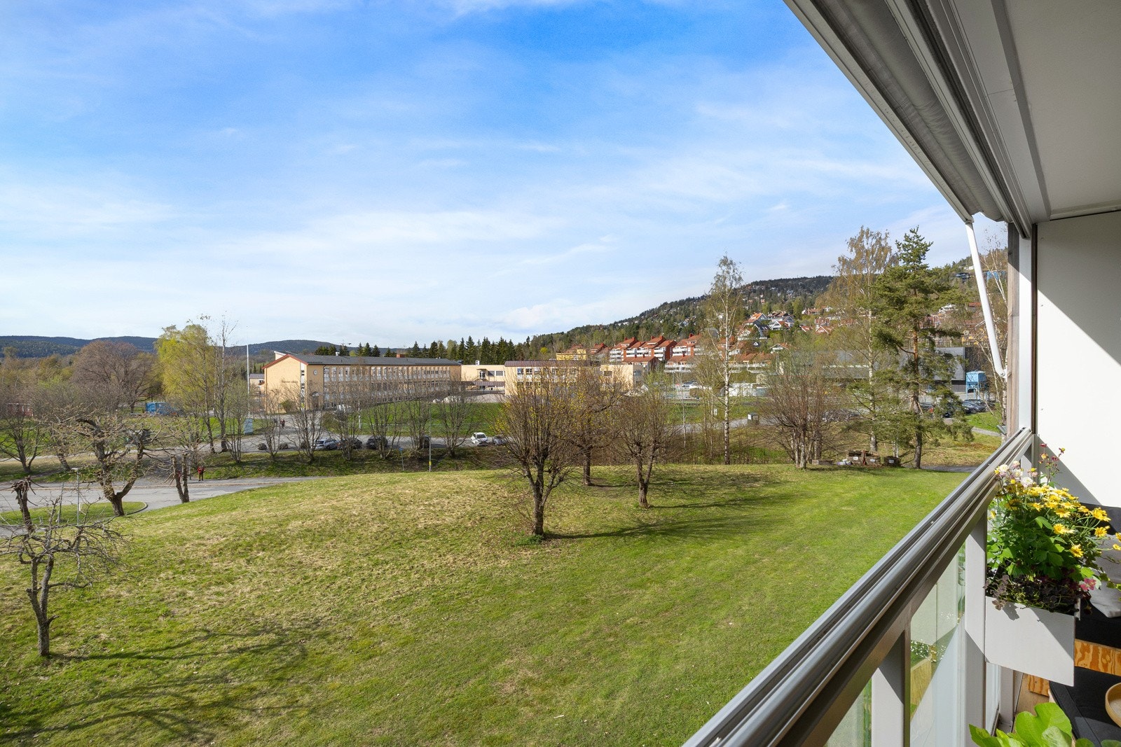 Utenfor balkongen er det fine grøntarealer med plen, trær og frukttrær. Området sogner til Voksen skole som ligger 'et steinkast' unna. Galleribilde