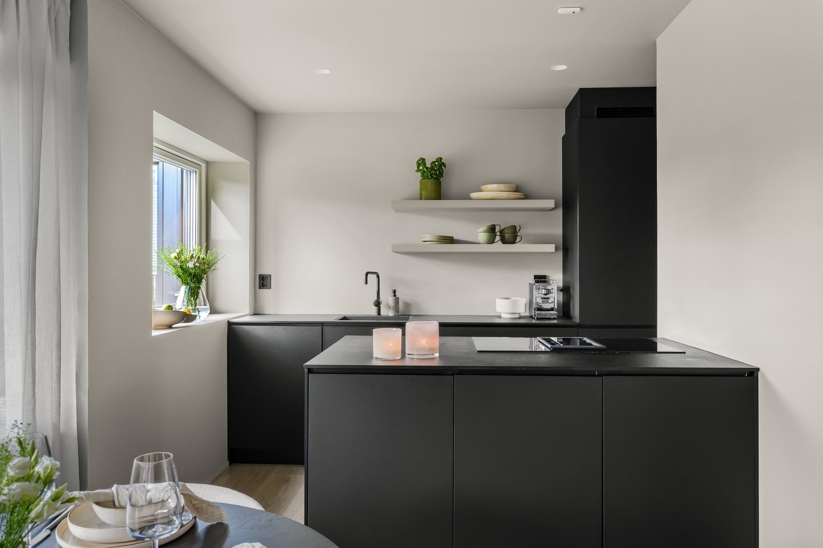 Innredningen har moderne, slette fronter og en slitesterk laminat benkeplate, mens veggen over benkene er malt i en stilren farge Galleribilde