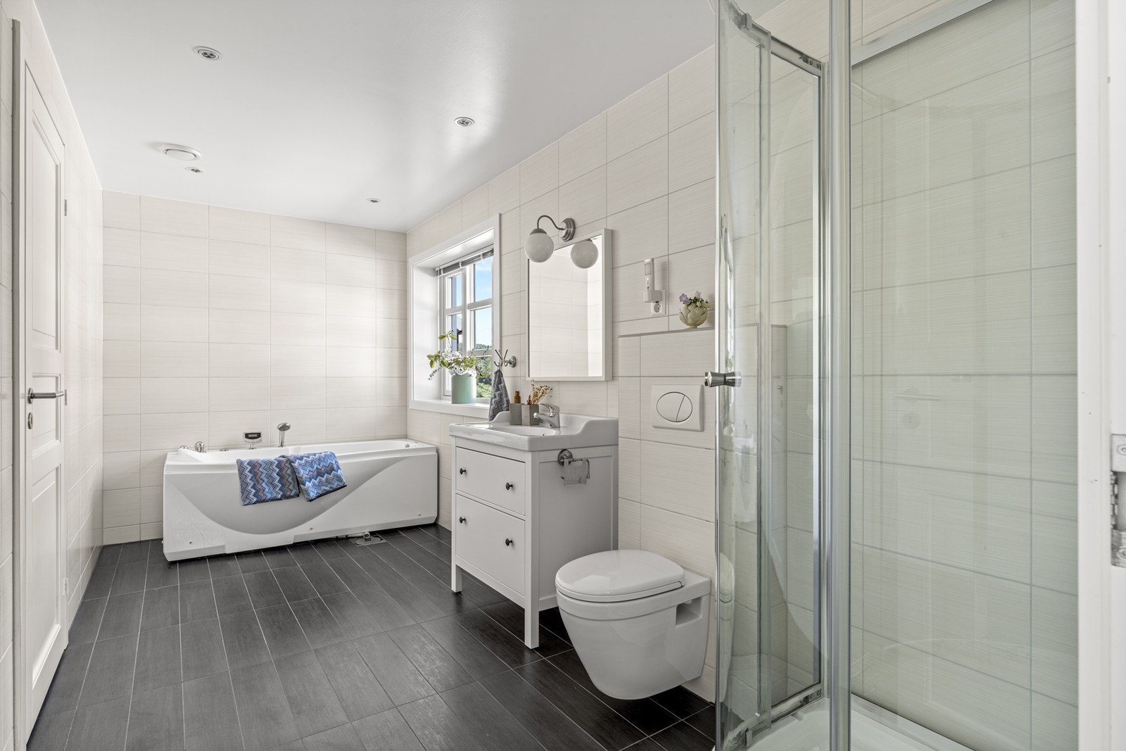 Helfliset bad i 1. etg med dusj, vegghengt wc, servant med skuffer og badekar. Galleribilde