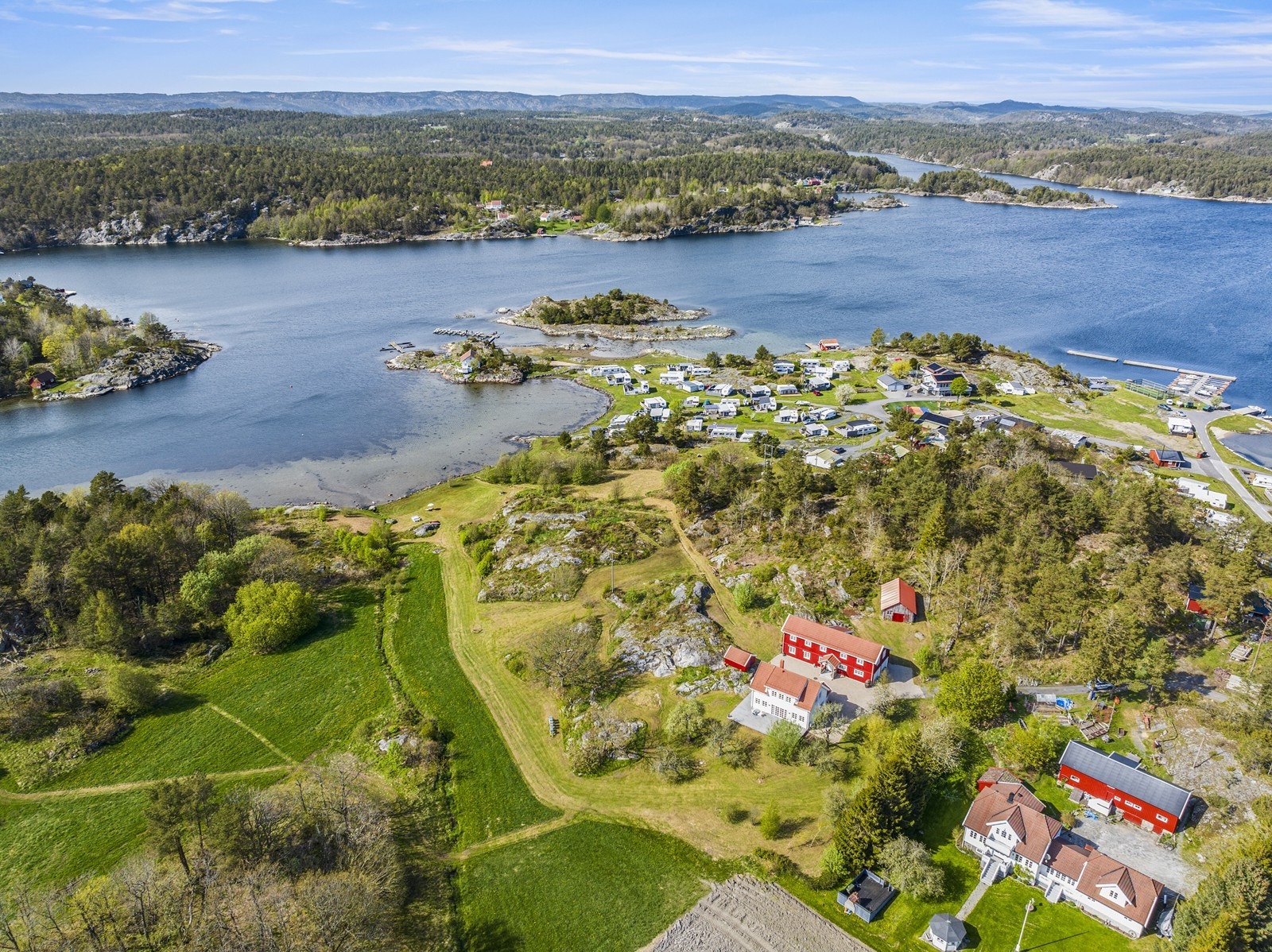Oversiktsbilde tatt med drone som viser eiendommen med ca 48 daa rundt og lang strandlinje mot bukta Galleribilde