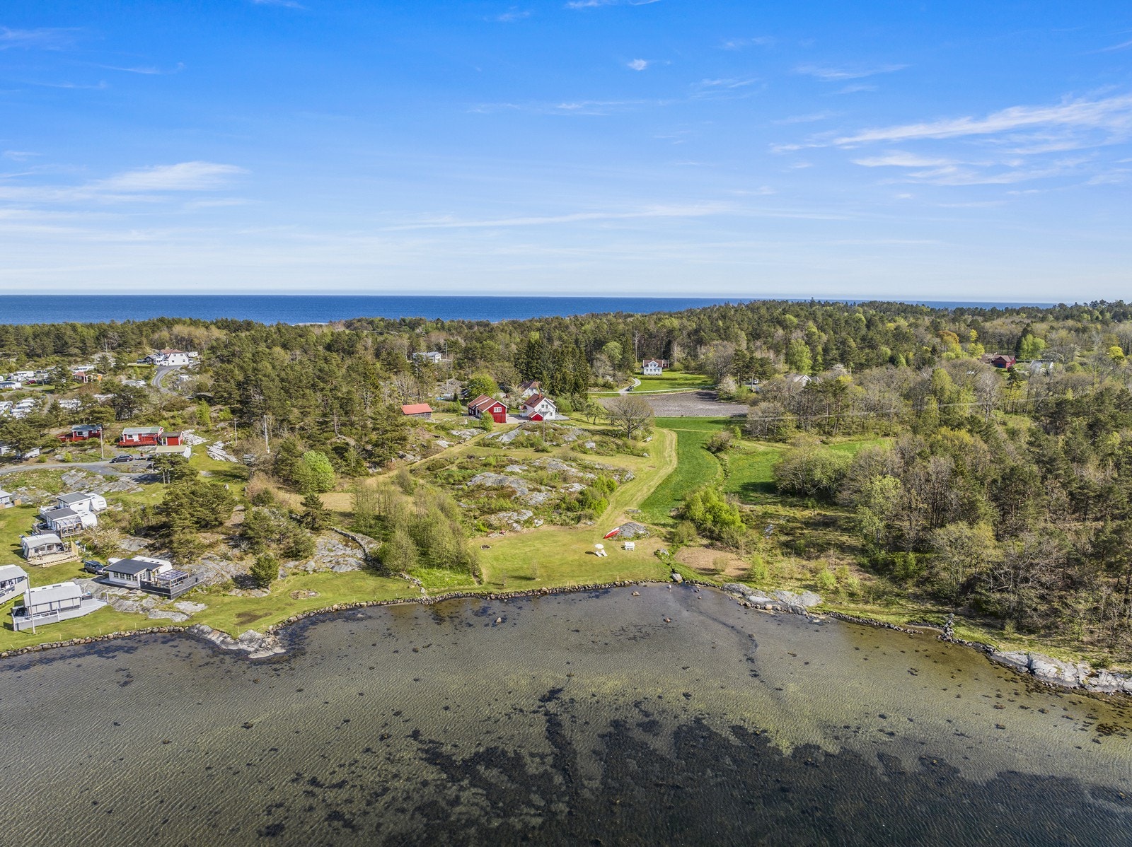 Oversiktsbilde som viser den lange strandlinjen som grenser mot Bufjorden camping i øst. Galleribilde