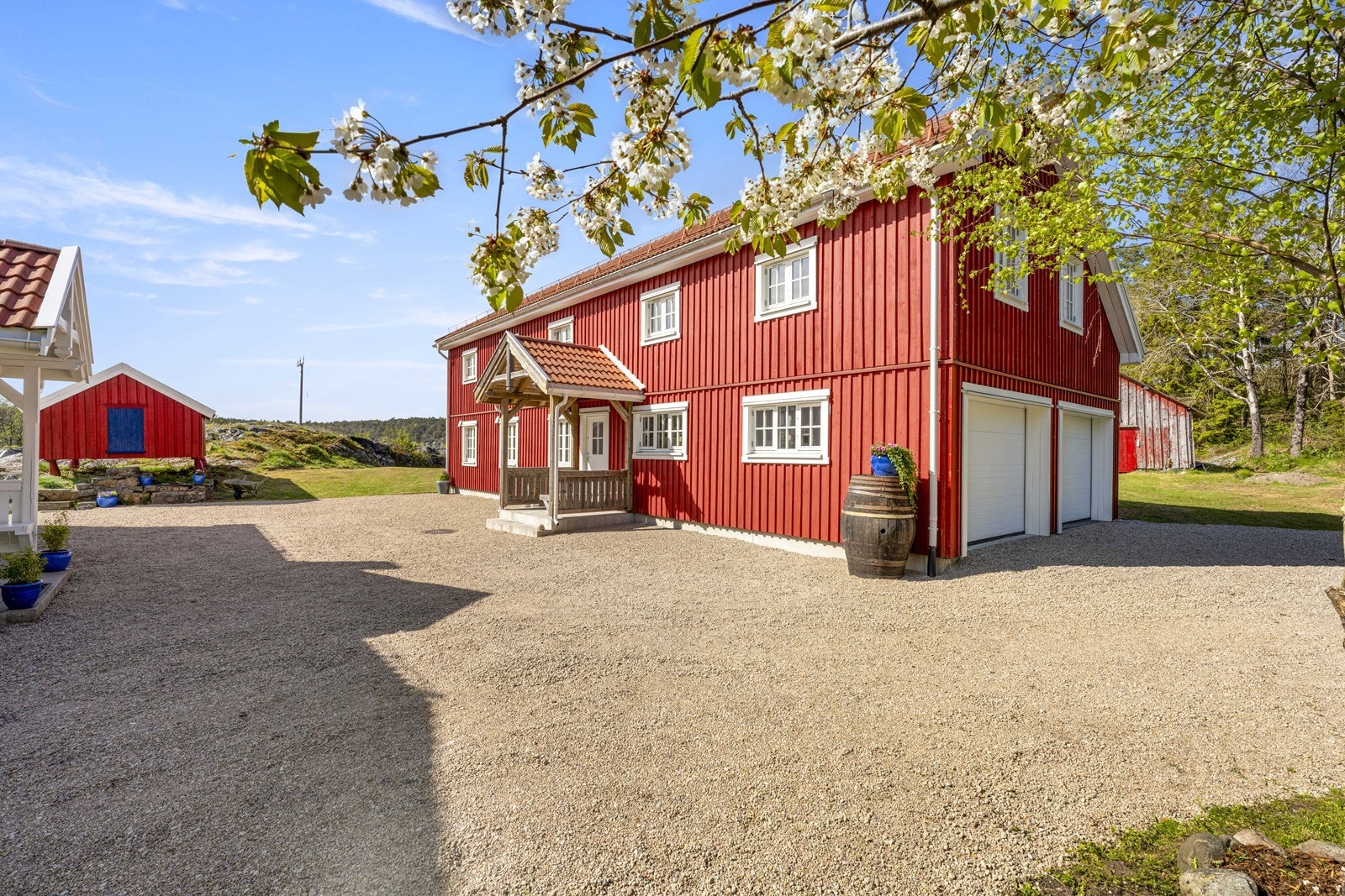 Koselig tun med låven som bla har dobbel garasje i enden Galleribilde