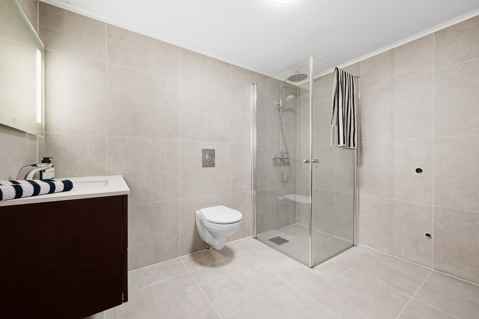 Badet i underetasjen inneholder servant med skapinnredning, berøringsfritt servantbatteri, speil med lys, vegghengt toalett, dusjnisje, samt opplegg for vaskemaskin. Galleribilde