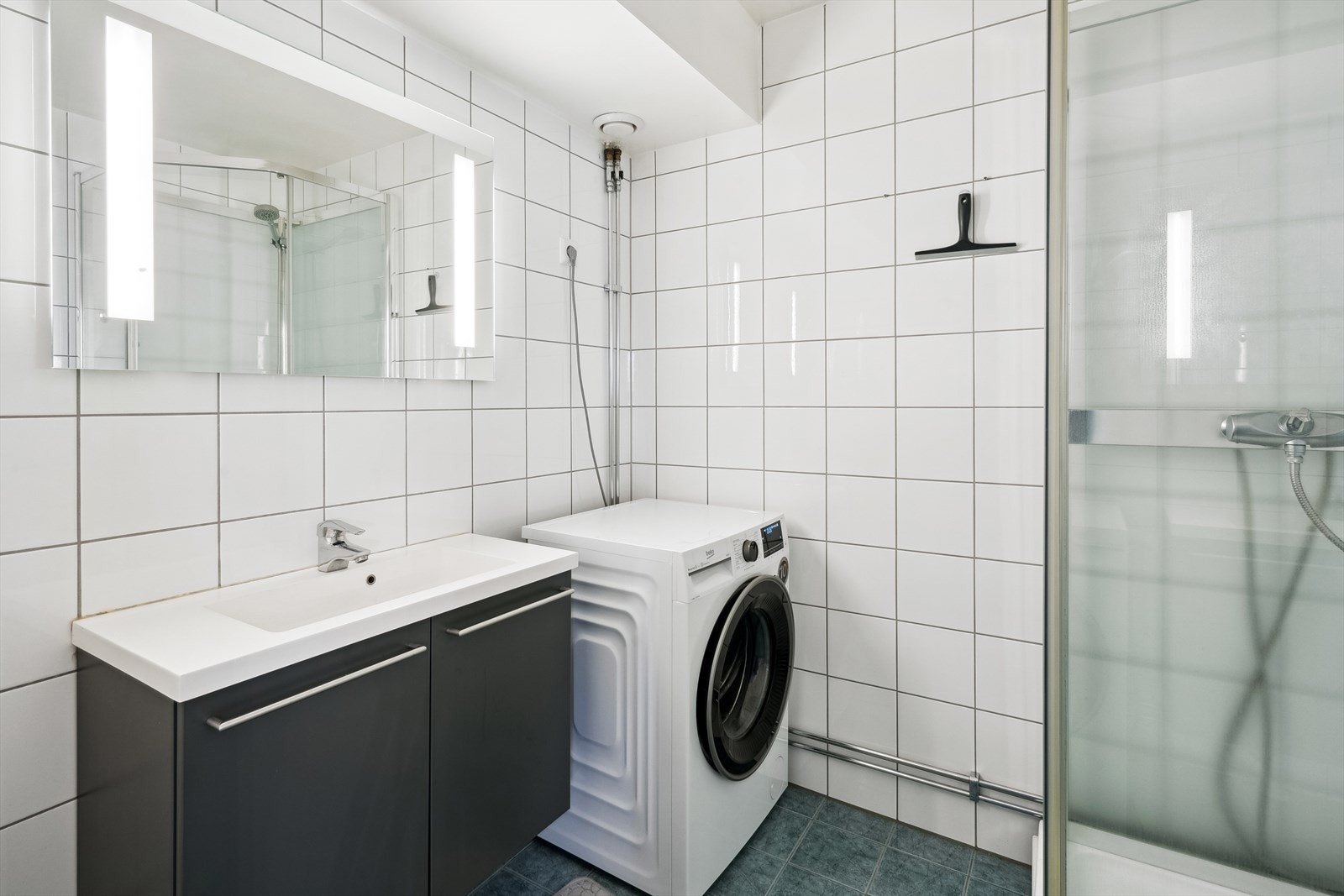 Pent flislagt bad med gulvvarme og opplegg for vaskemaskin Galleribilde