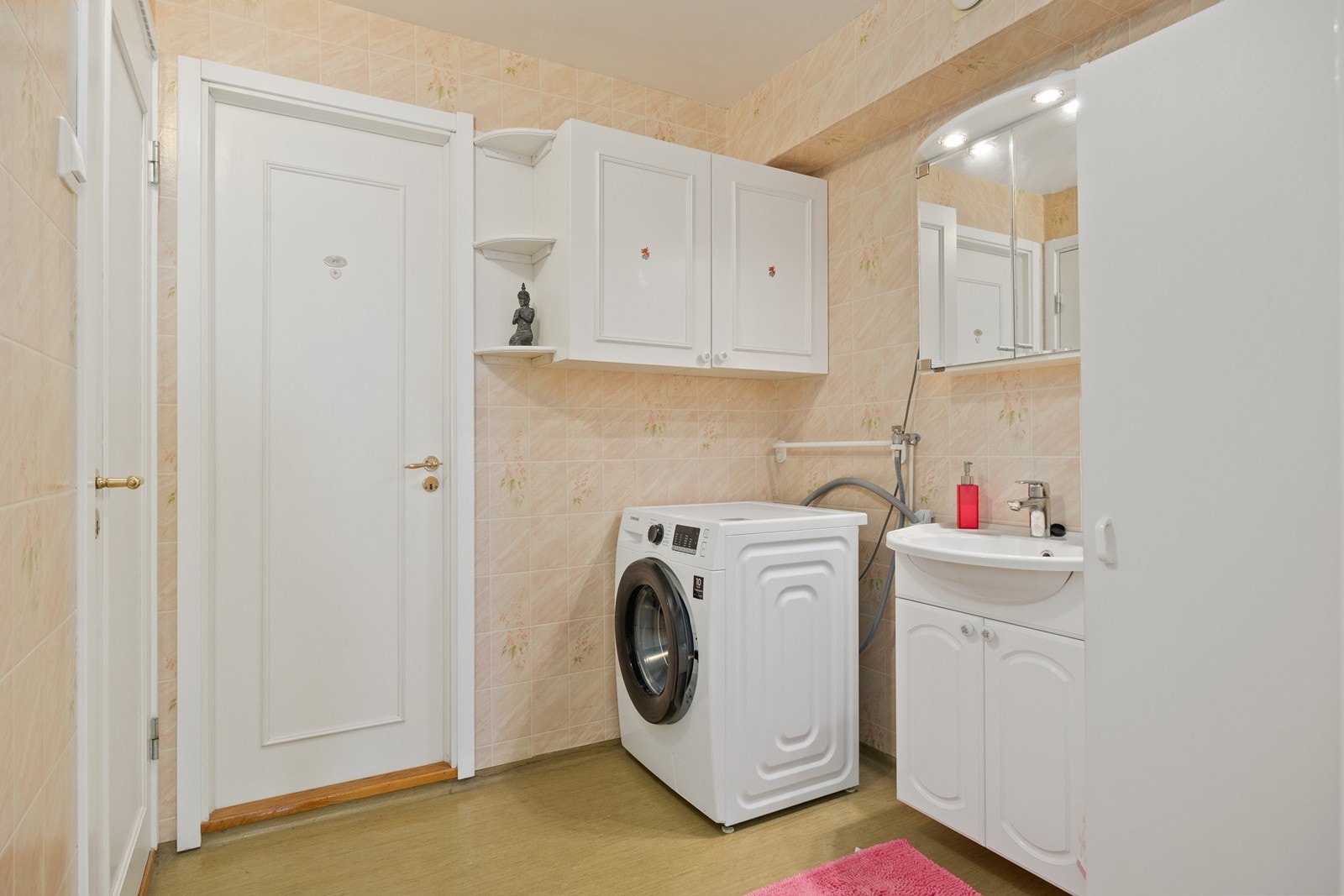 Vaskerom med opplegg til vaskemaskin. Vask med innredning og speilskap. Galleribilde