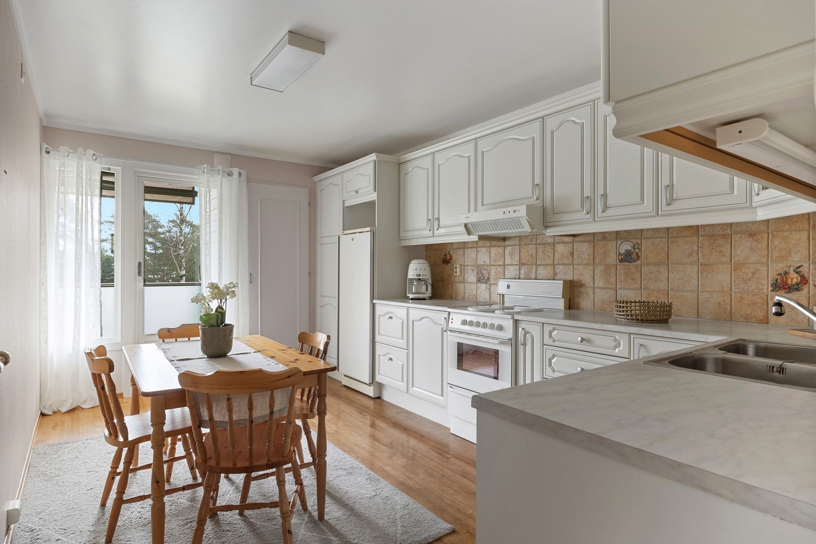 Det romslige kjøkkenet har god plass til både spisebord og en praktisk matbod for ekstra oppbevaring. Galleribilde