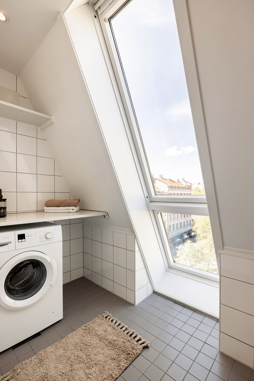 Badet er smart delt inn med en egen vaskesone med opplegg for vaskemaskin og praktiske hyller for oppbevaring. Galleribilde