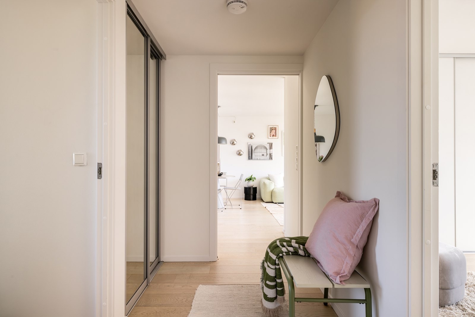 Velkommen inn i en lys og praktisk entré med skyvedørsgarderobe med speilfronter for yttertøy. Galleribilde
