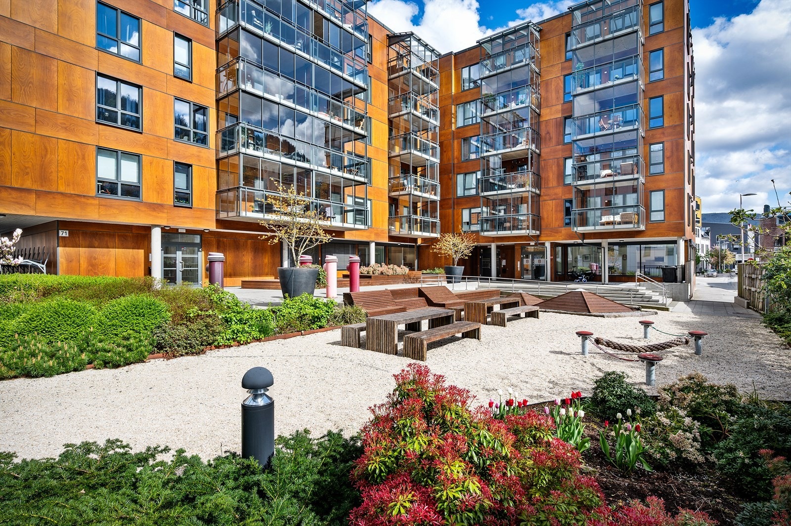 Fellesarealet er pent opparbeidet med beplantning, felles utemøbler og lekeareal. Galleribilde