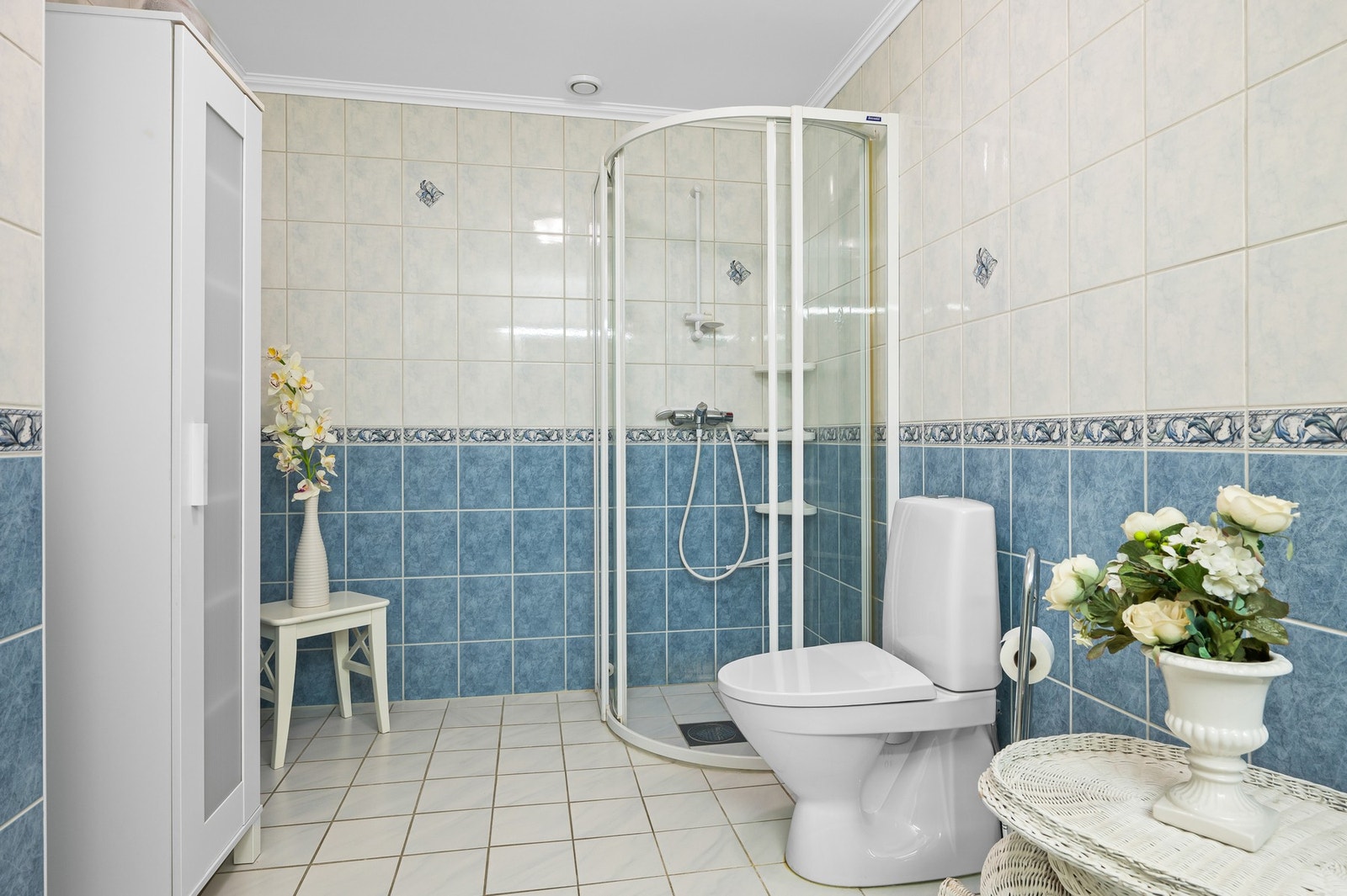 Badet er utsyrt med dusjhjørne, WC, servant og store servantskap. Galleribilde