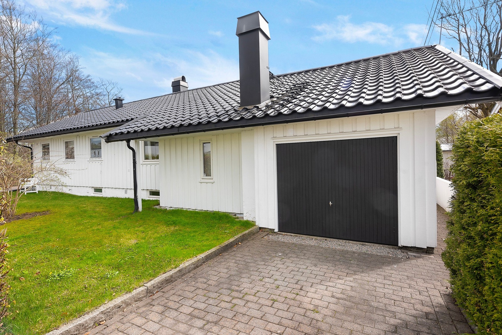 Det er god plass til parkering i både innkjørsel og garasje, og du har adkomst til baksiden av huset langs gjerdet Galleribilde
