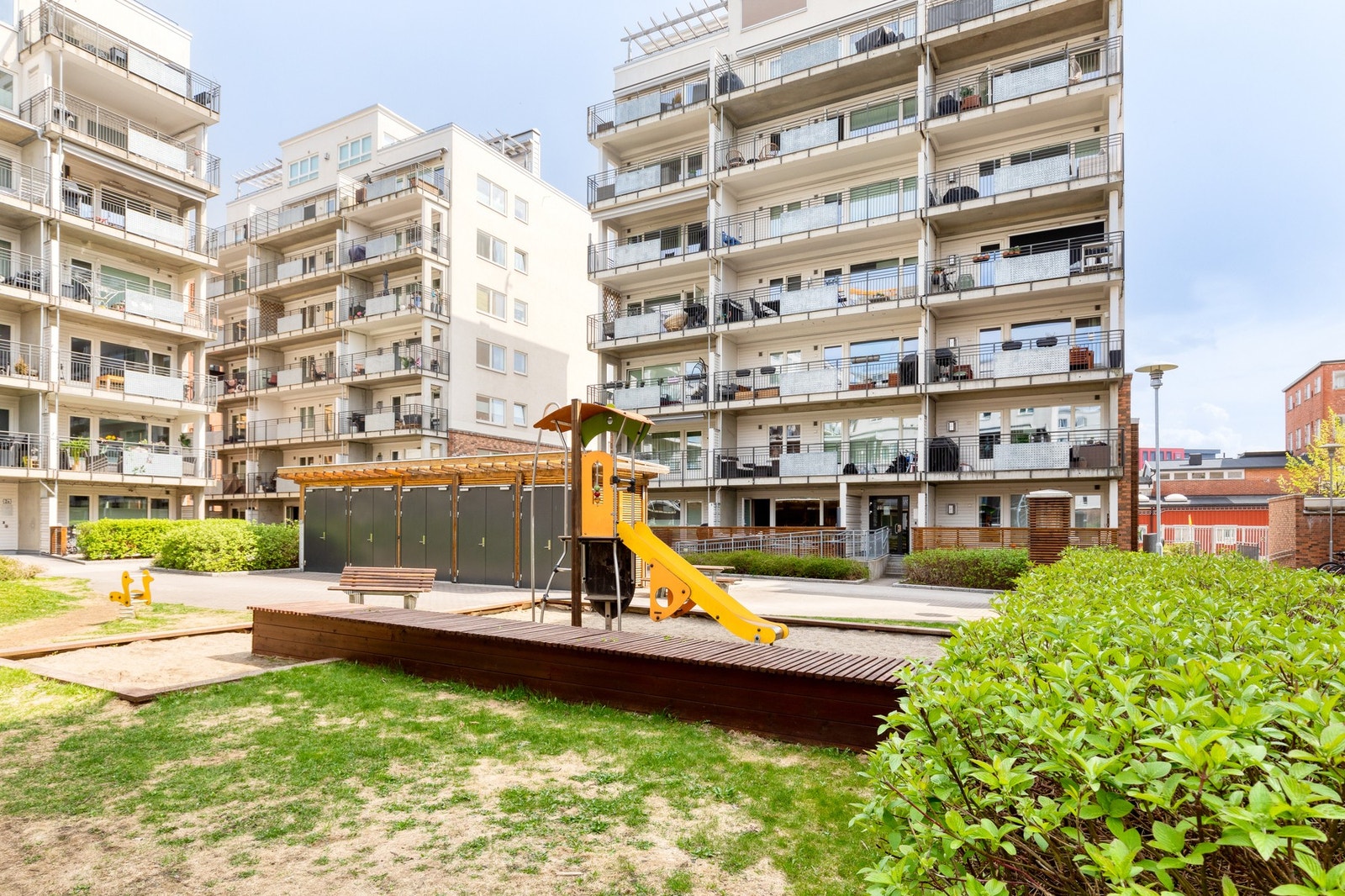 Bilfrie og pent beplantet fellesarealer mellom bebyggelsen på boligfeltet. Galleribilde