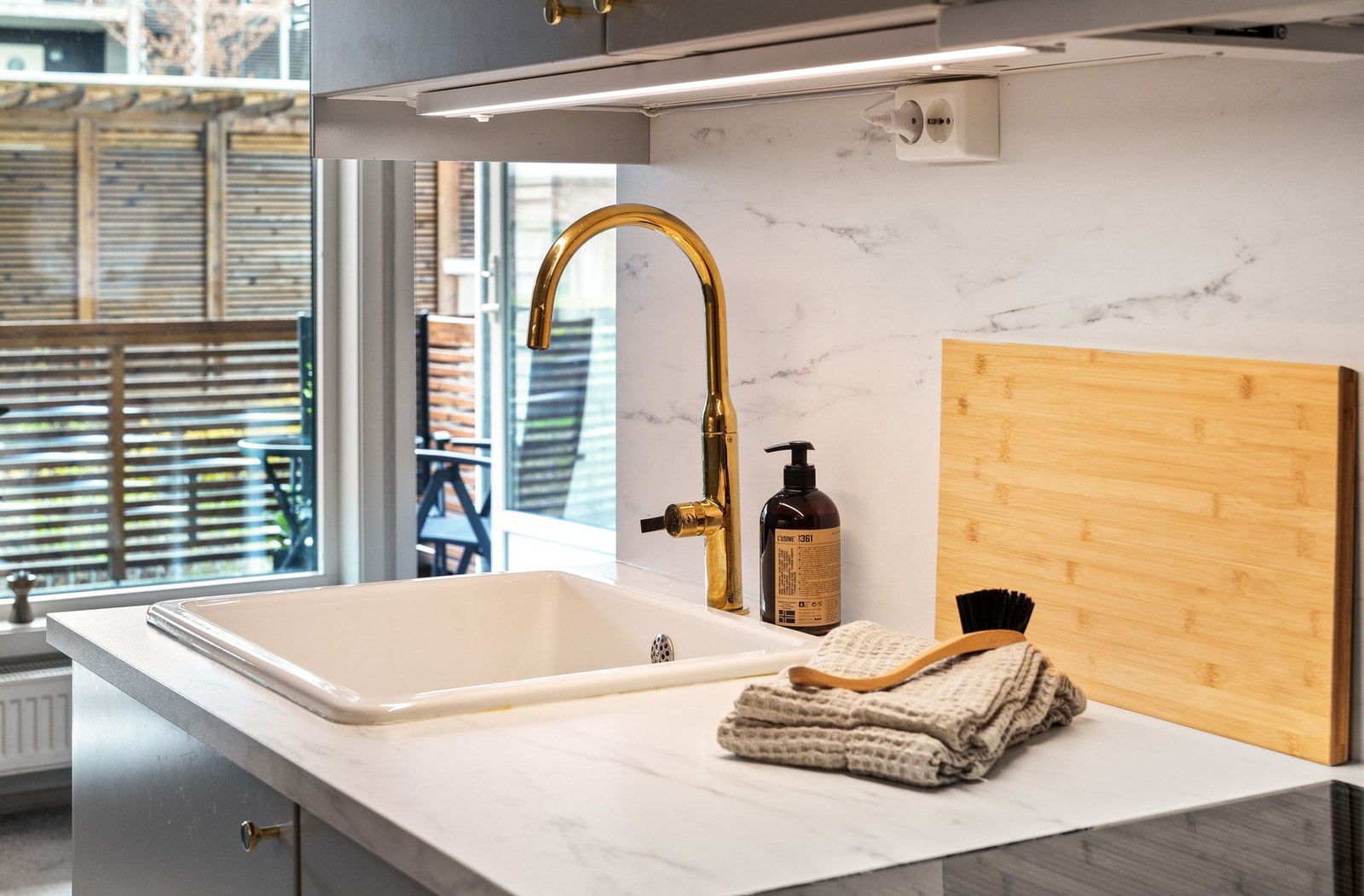 Kjøkkeninnredningen har glatte fronter og laminat benkeplate med nedfelt kum. Det er belysning under overskapet. Galleribilde