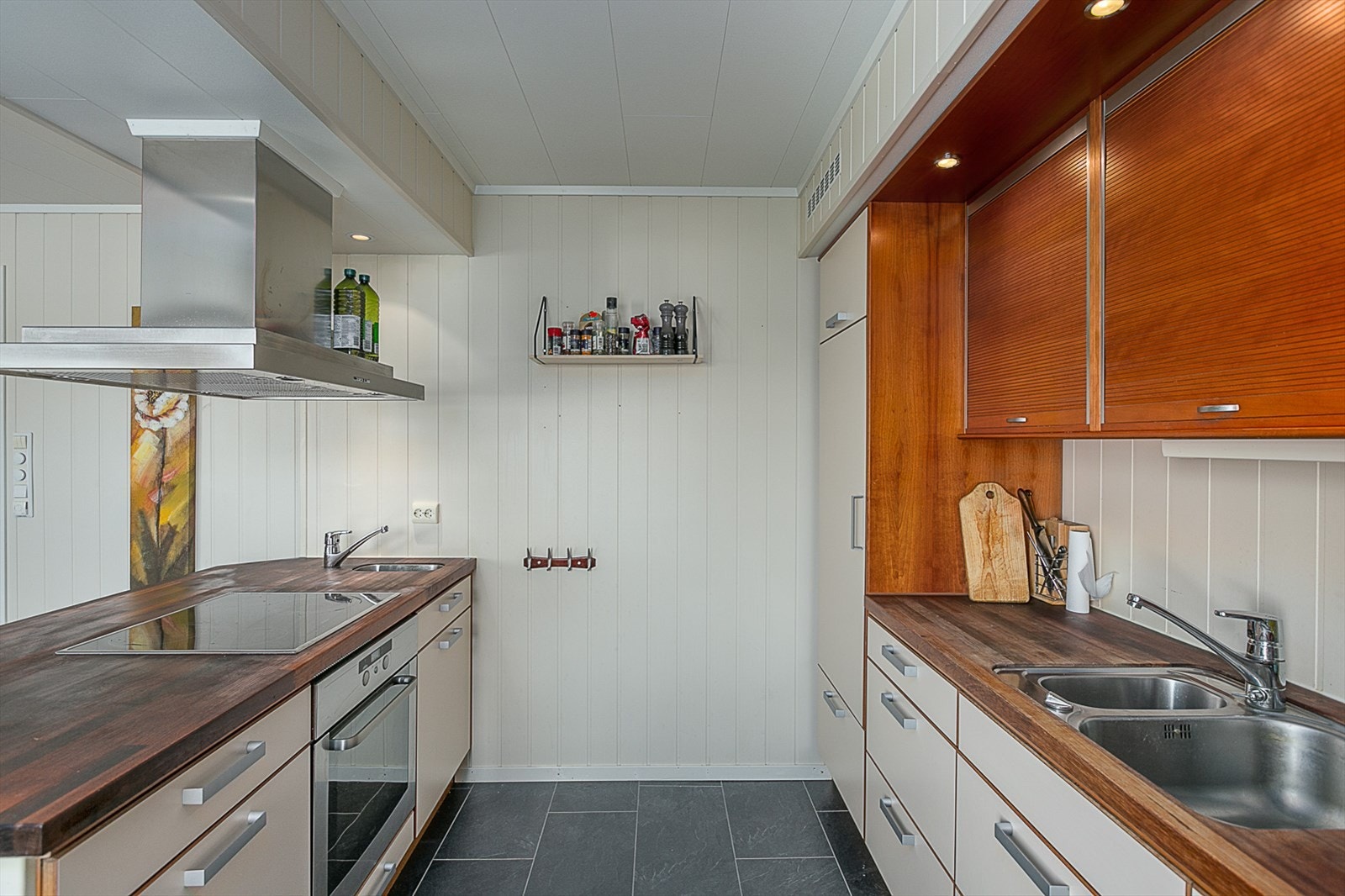 Kjøkken med integrert koketopp, komfyr og kjøleskap. Galleribilde