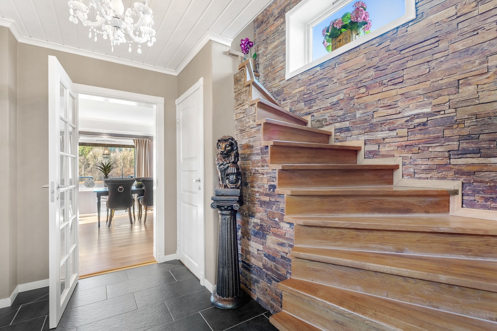 Fra entreen er det videre adkomst til en pen gang i samme stil med trapp til etasjen over og skyvedørsgarderobe med speilfronter. Galleribilde