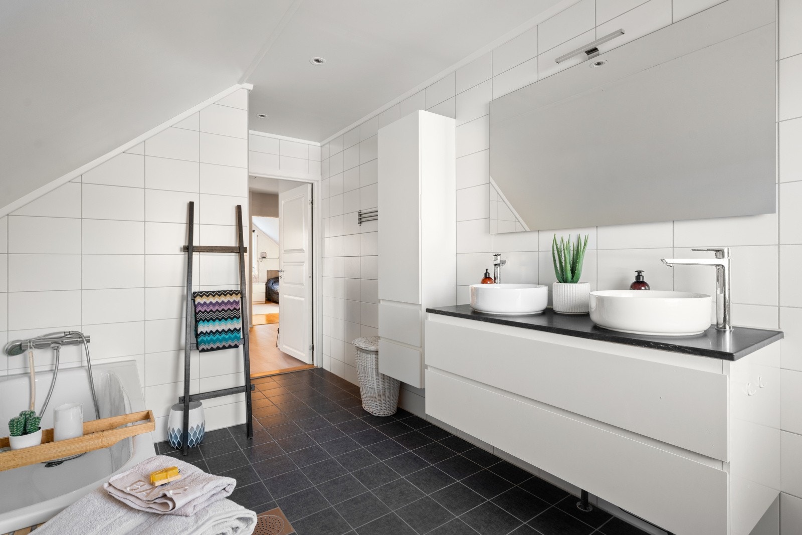Pent baderom med flislagte vegg- og gulvflater samt downlights i himling og gulvvarme Galleribilde