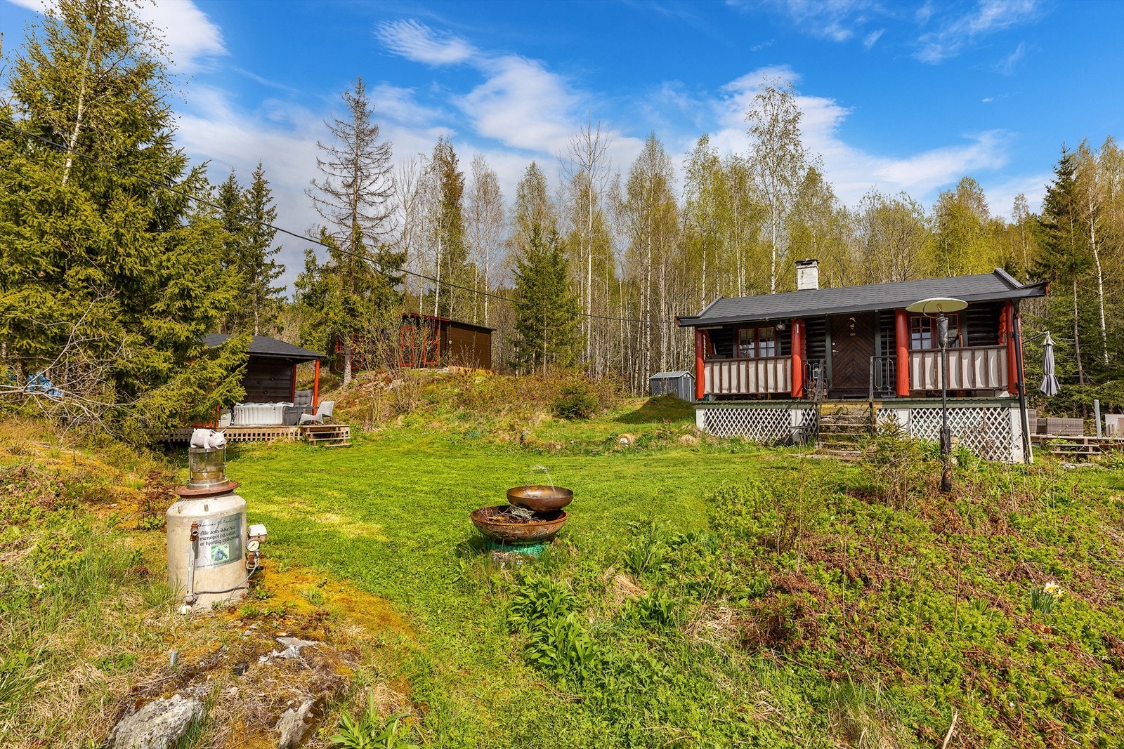 Idyllisk eiendom med hytte og anneks - omgitt av vakker natur og skog. Her finnes flere solrike uteplasser, inkludert en romslig terrasse og et anneks med egen terrasse på ca. 11 kvm - perfekt for avslapping Galleribilde