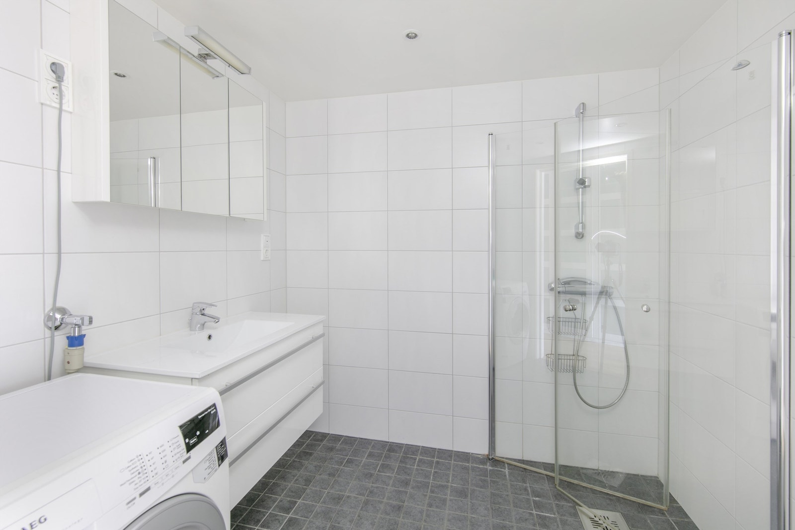 Pent flislagt bad med opplegg for vaskemaskin. Galleribilde
