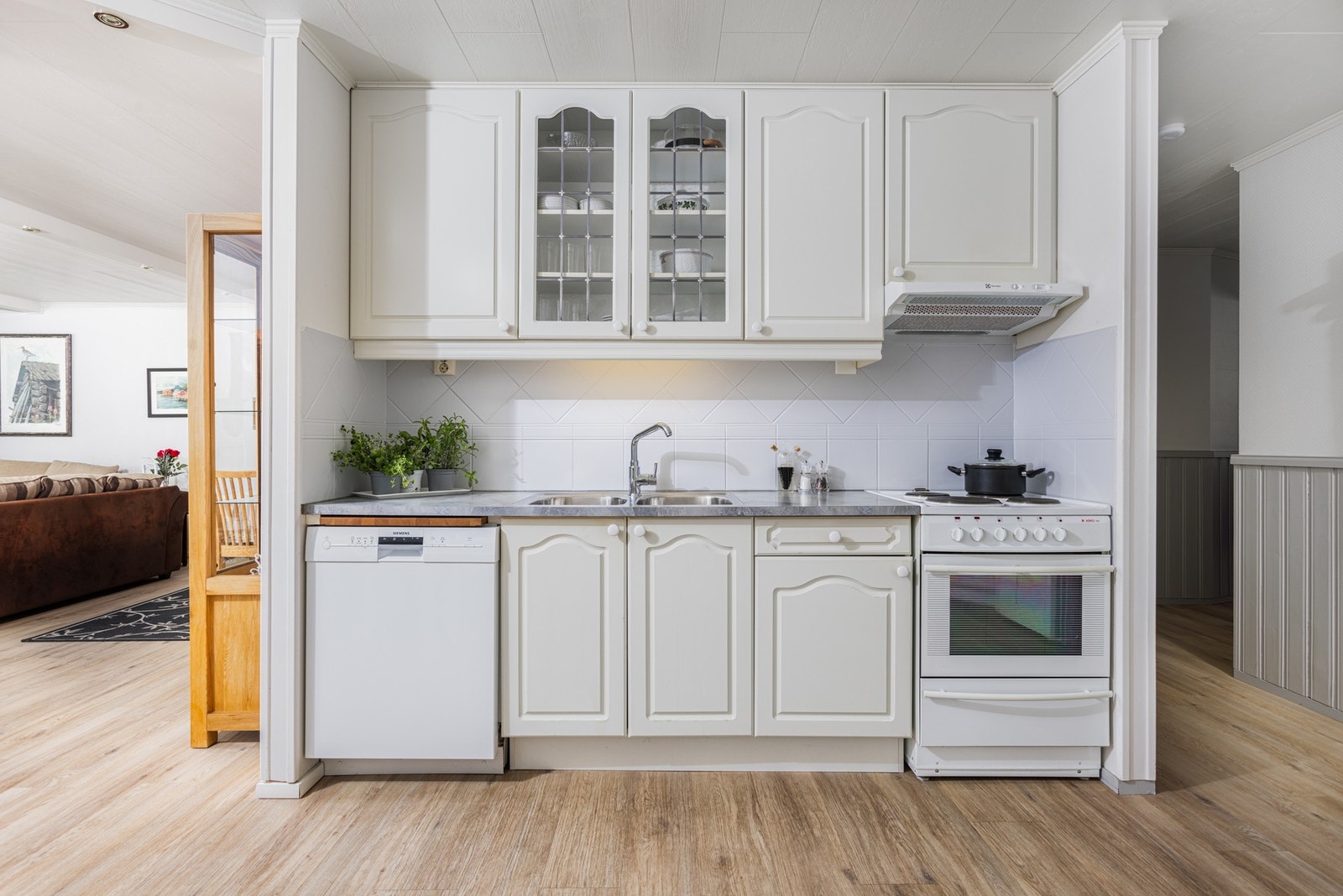 Kjøkkenet er av kjøkkeninnredning med fronter i hvit profilert utførelse. Galleribilde