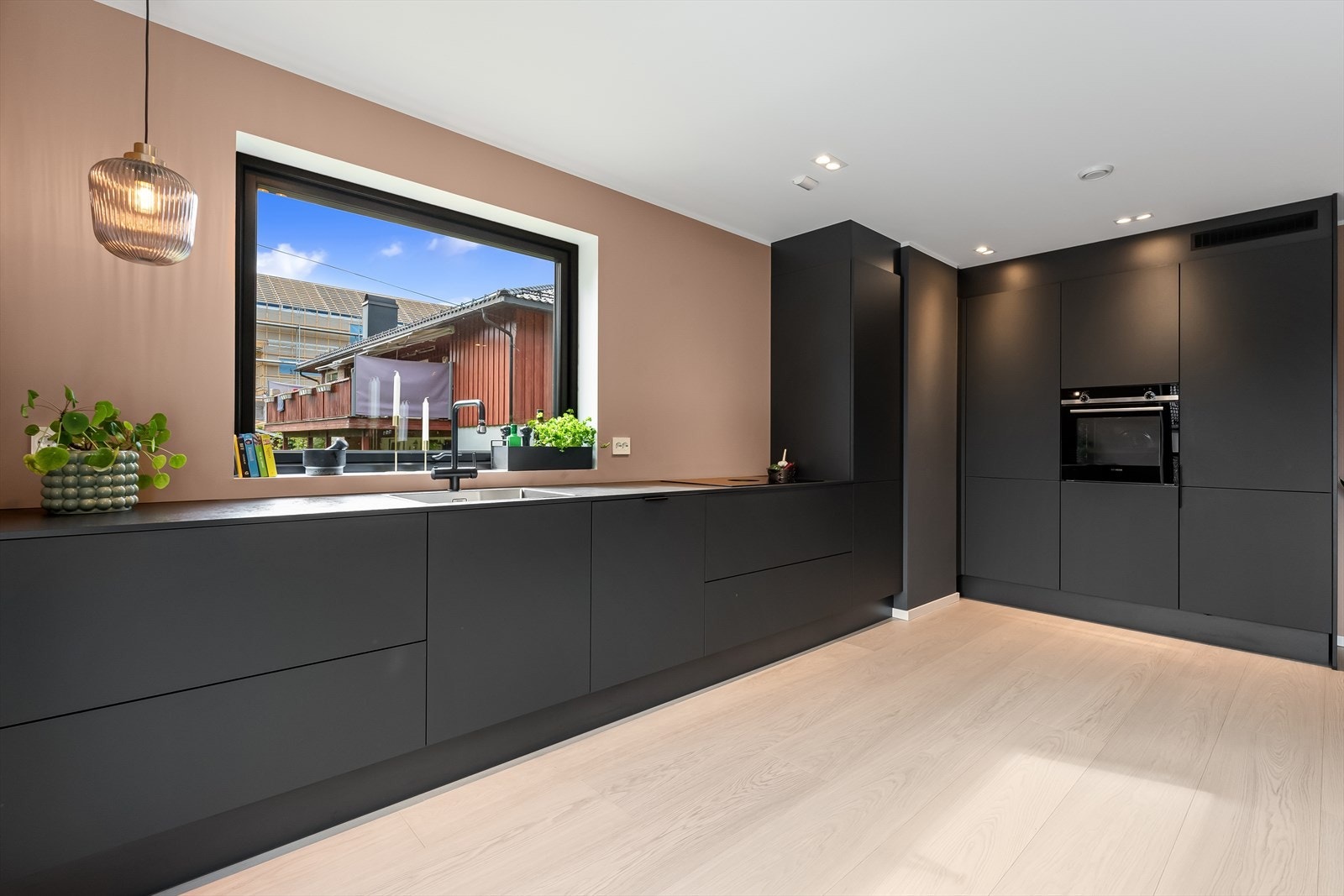 Stilren kjøkkeninnredning fra Schüller med integrerte hvitevarer (stekeovn, kjøl/frys og oppvaskmaskin) - Mekanisk avtrekk fra ventilator integrert i platetopp fra Bora Galleribilde