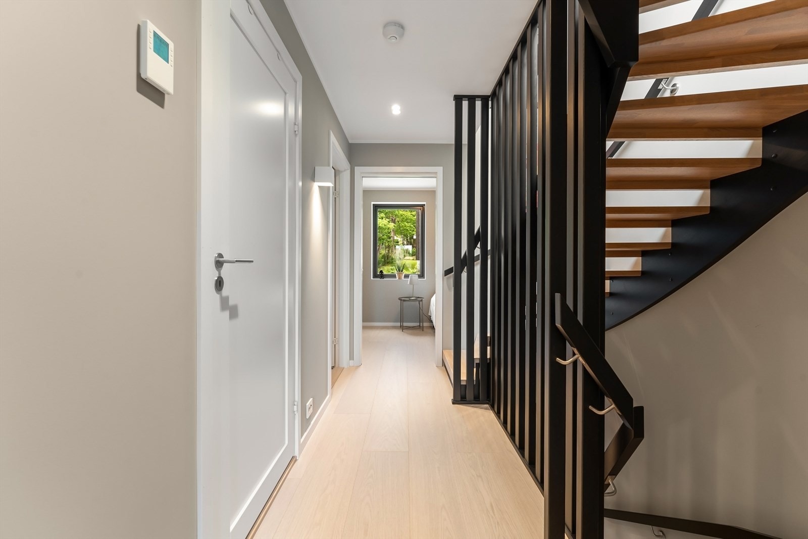 Stilren, malt tretrapp med trinn i eik binder boligens etasjer sammen Galleribilde