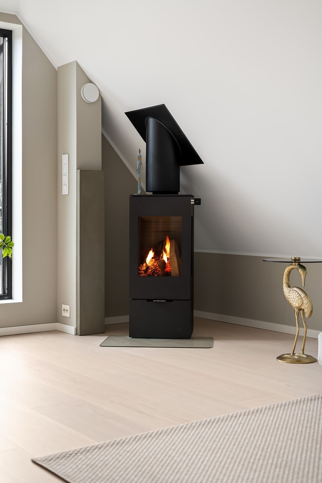 Stilren og effektiv peisovn varmer godt og gir en lun og god atmosfære på kaldere dager - Vifte i pipeløp betjenes med fjernkontroll Galleribilde