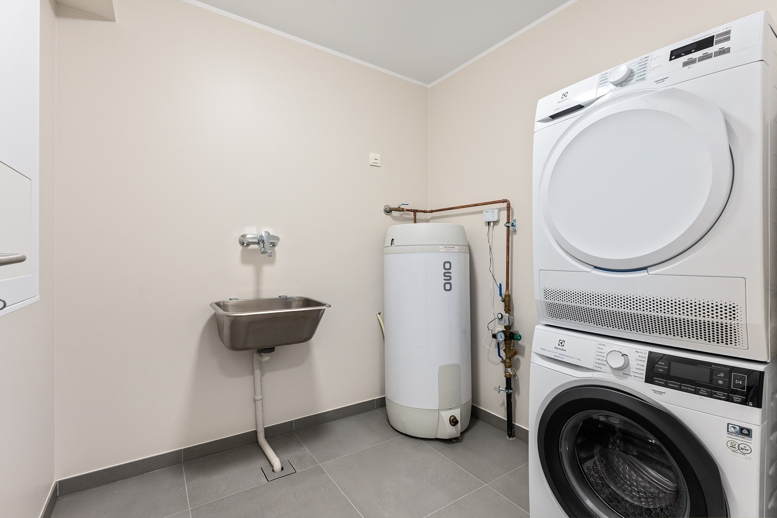 Svært praktisk vaskerom i kjeller med god plass til vask/tørk, samt innredning til oppbevaring Galleribilde