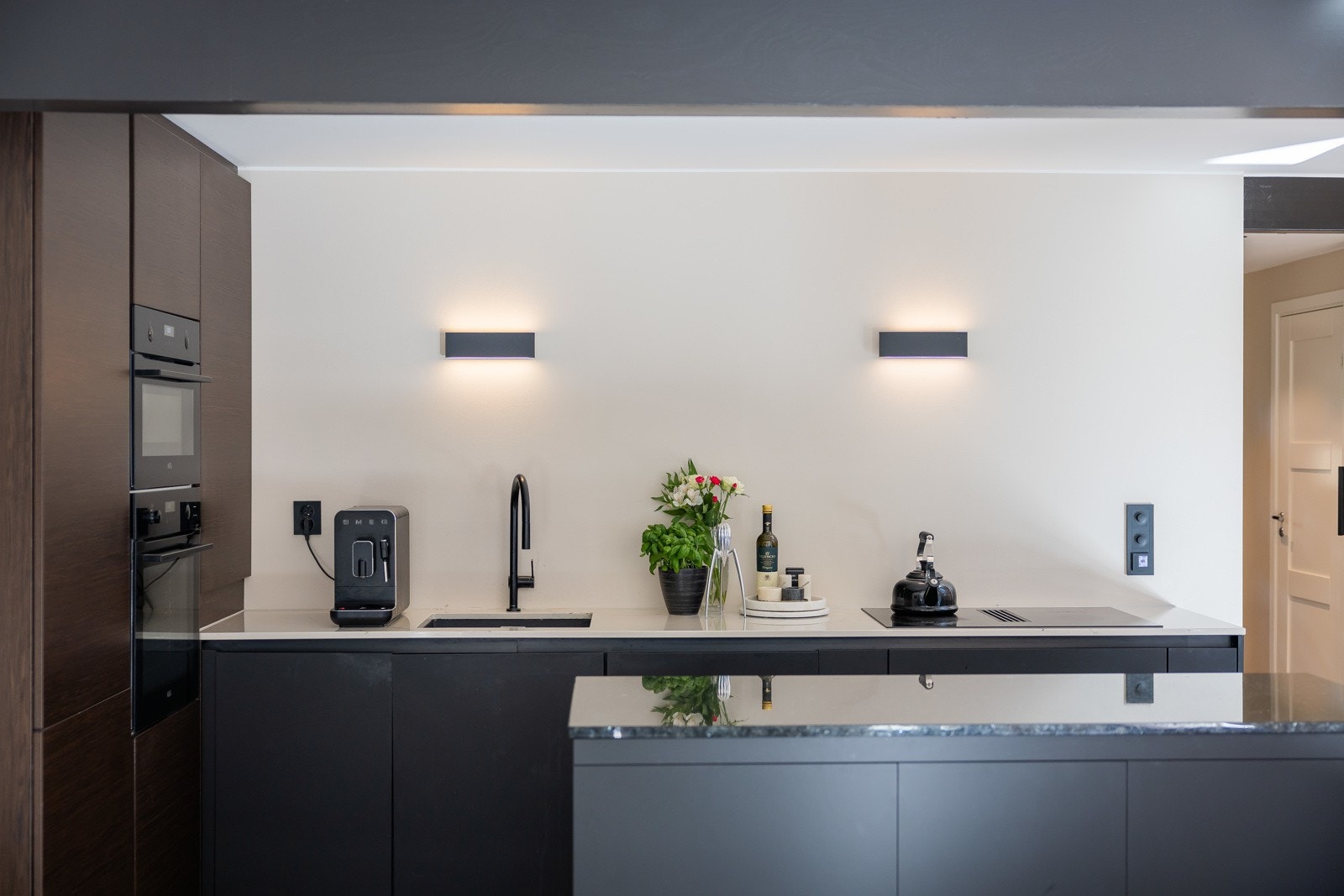 kjøkkenet utstyrt med integrerte hvitevarer, inkludert kjøleskap/fryser og oppvaskmaskin. I tillegg er det innebygget stekeovn og mikrobølgeovn elegant plassert i høyskap. Galleribilde