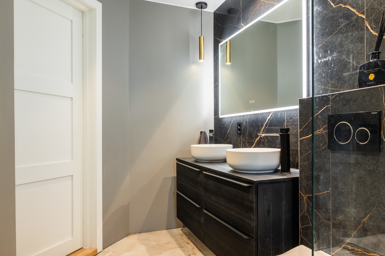 Dobbel servant med underskap og ettgreps blandebatterier gir både stil og funksjonalitet, og speil med integrert belysning setter prikken over i'en. Galleribilde