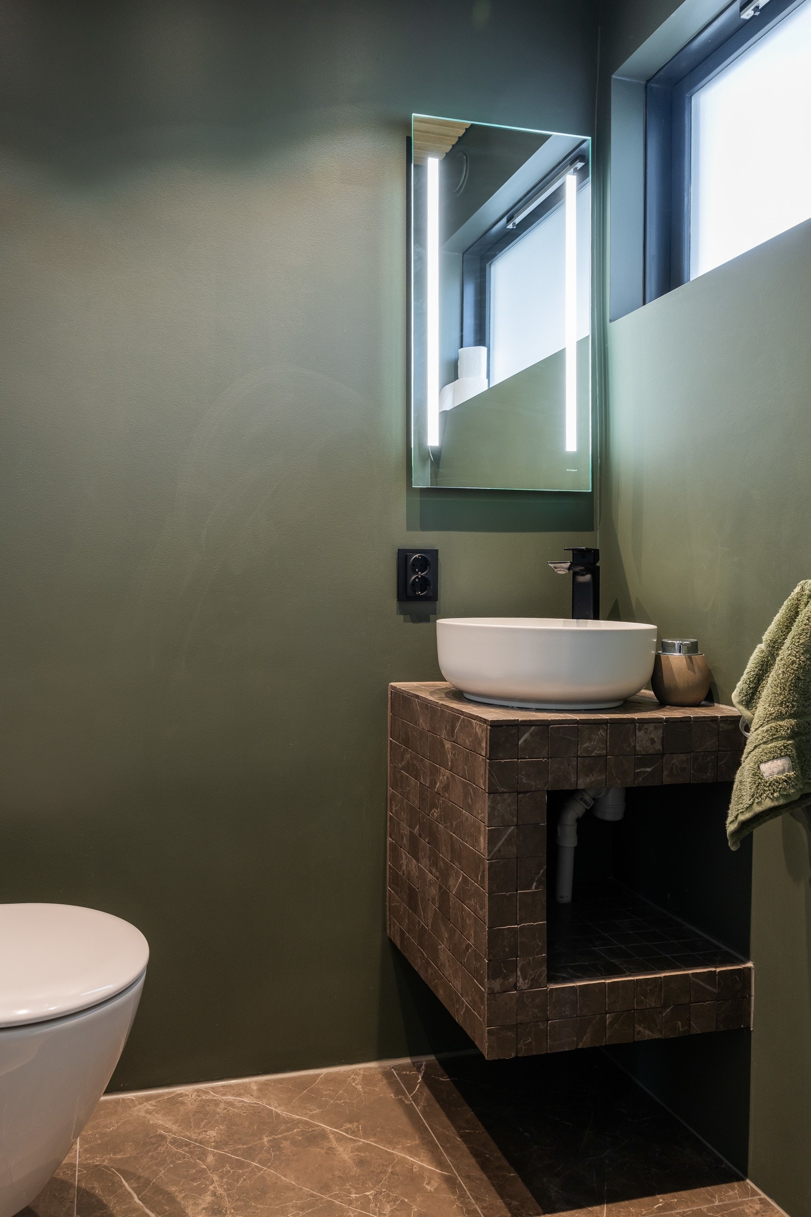 Toalettrommet i 1.etg. fremstår som moderne med flislagt gulv og malte veggflater i en behagelig fargetone. Galleribilde