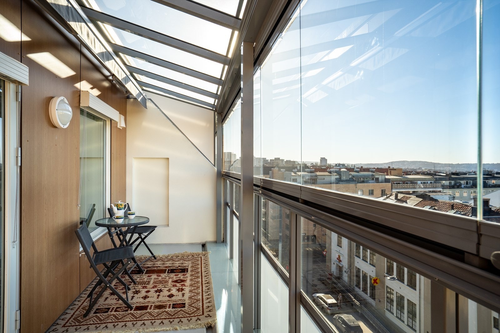 Innglasset balkong med plass til spisegruppe og planter. Galleribilde