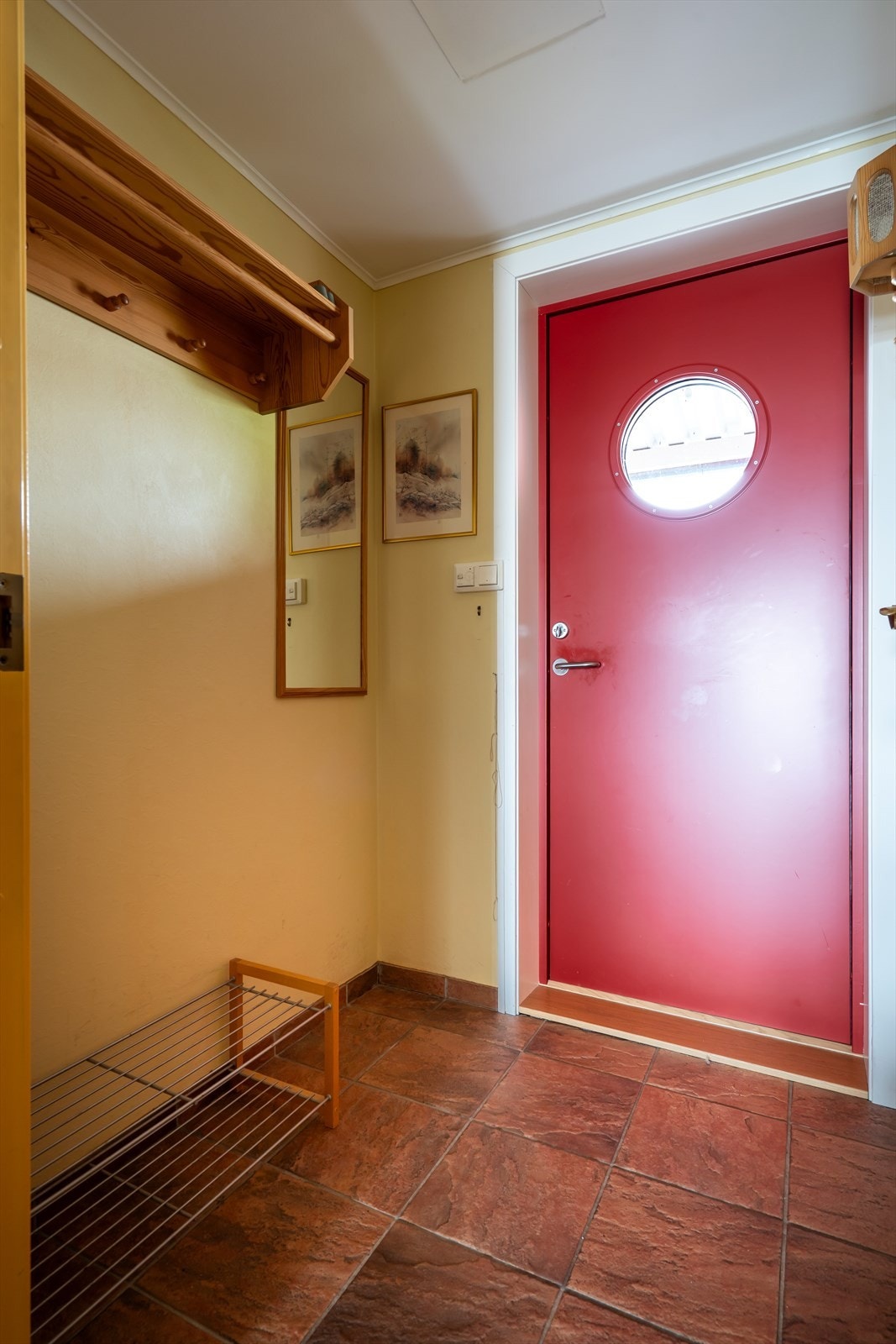 Entré med flislagt gulv og plass til skooppbevaring. Galleribilde