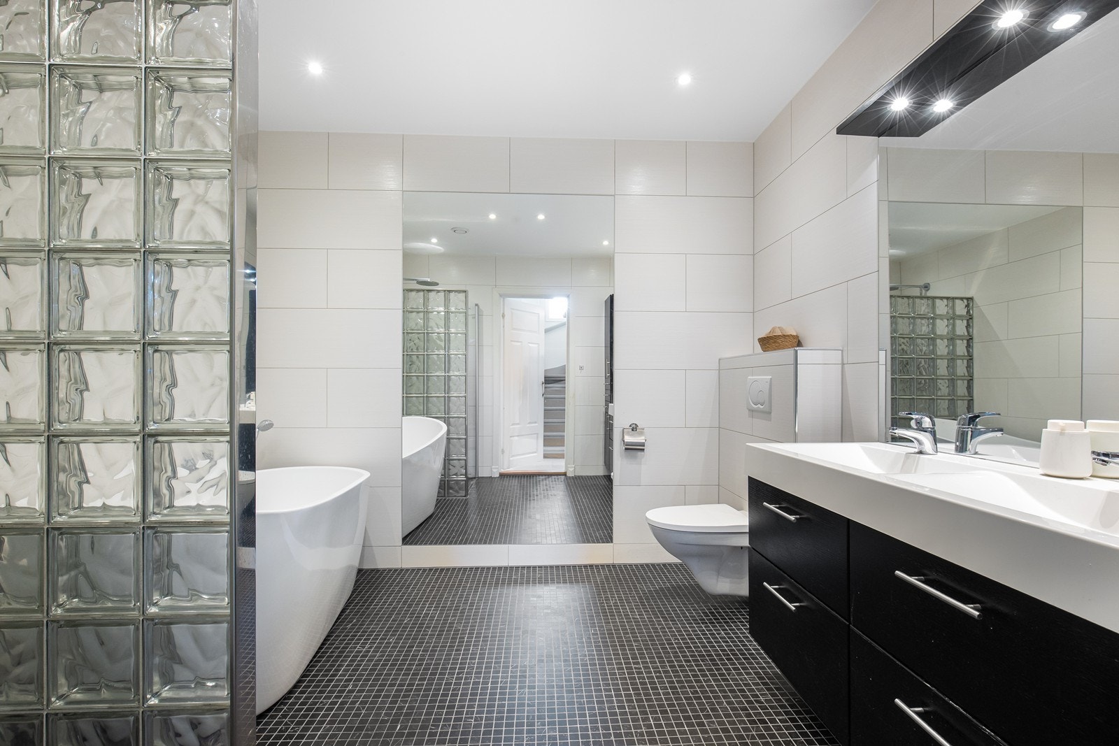 Stort bad i 1. etasje frittstående badekar, dusjnisje, vegghengt wc og dobbel servantinnredning. Galleribilde