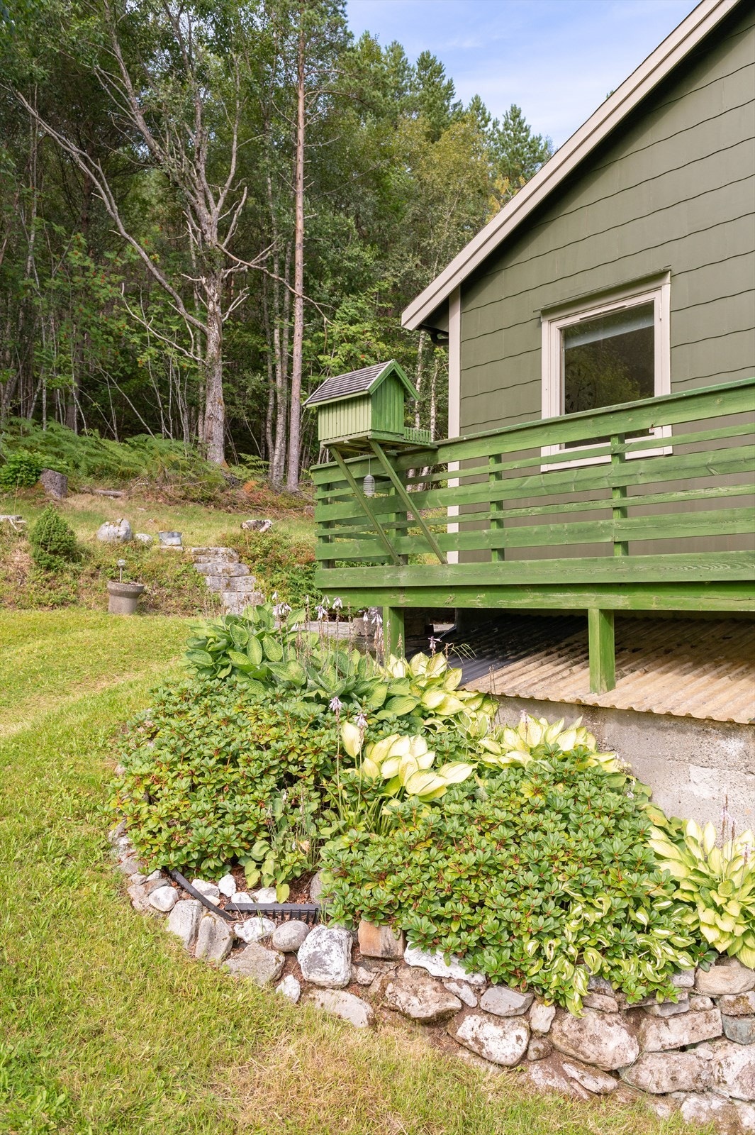 Rundt boligen er det opparbeidet flere fine blomsterbed Galleribilde